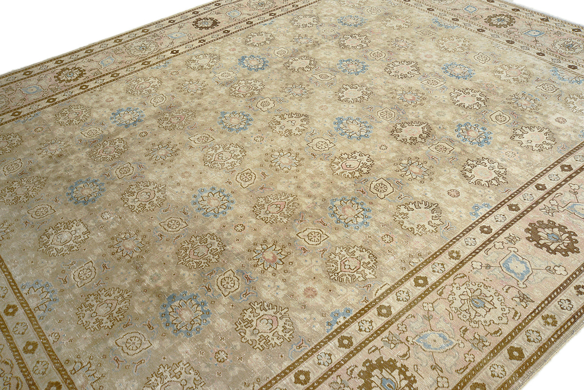 Detailed Tabriz carpet field showing soft floral patterns in ivory and muted blue