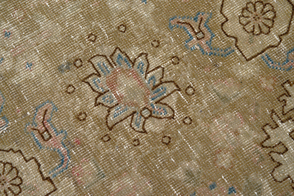 Close-up of Persian Tabriz carpet featuring delicate floral patterns and subtle blue accents