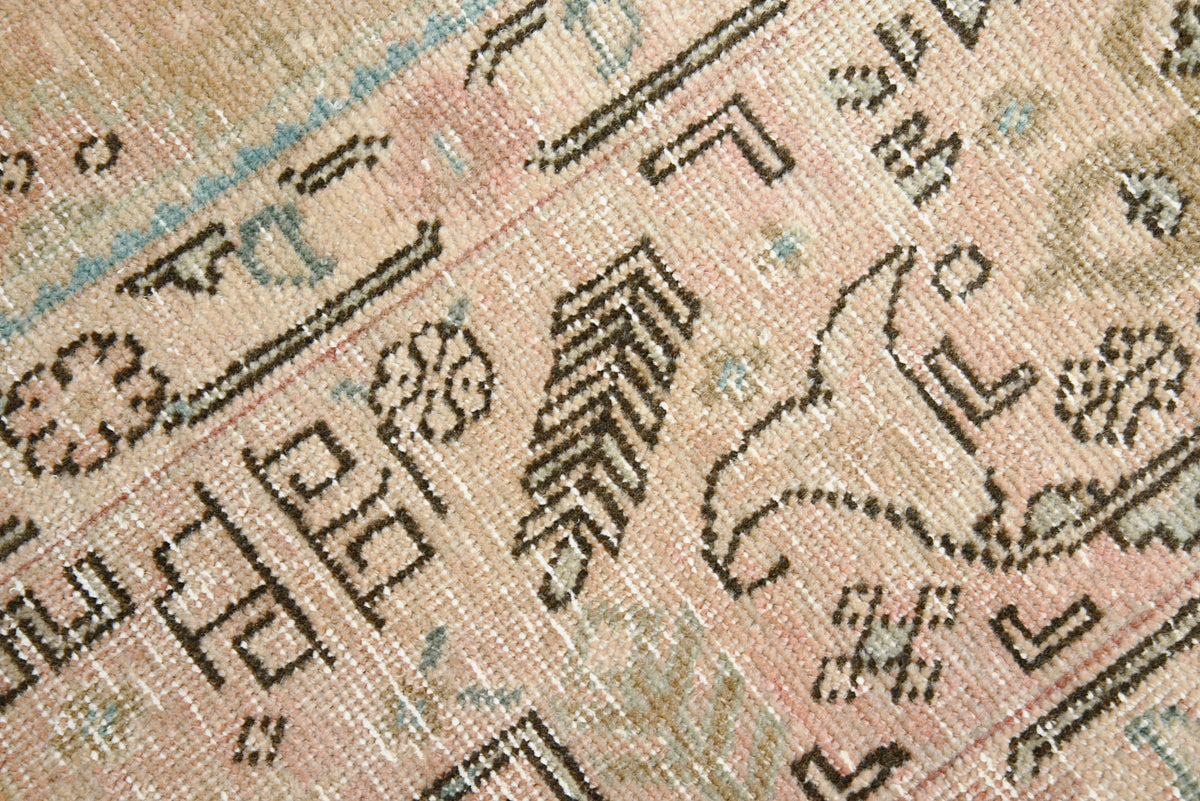 Detailed corner of vintage Tabriz carpet featuring geometric motifs and muted earth tones