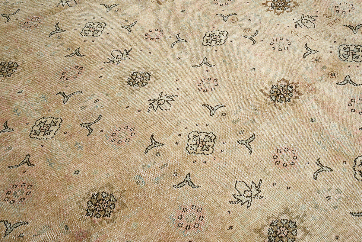 Close-up of Persian Tabriz carpet showing subtle all-over patterns and natural aged texture