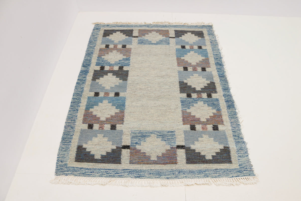 Full view of vintage Swedish Kilim rug with repeating geometric border motifs