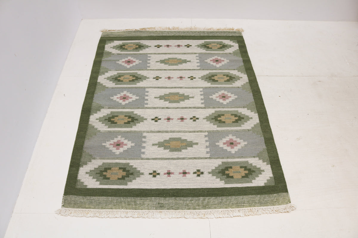 Full view of vintage Swedish Kilim rug with alternating geometric bands and floral motifs