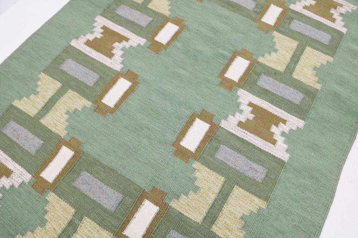 Close-up of vintage Kilim rug featuring pale blue and cream geometric woven details