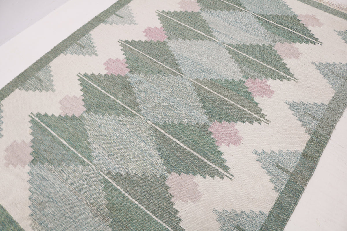 Detailed view of vintage Swedish Kilim rug with repeating geometric diamond pattern