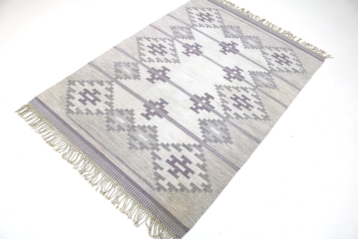 Angled view of Swedish Kilim featuring repeating diamond and cross-shaped motifs