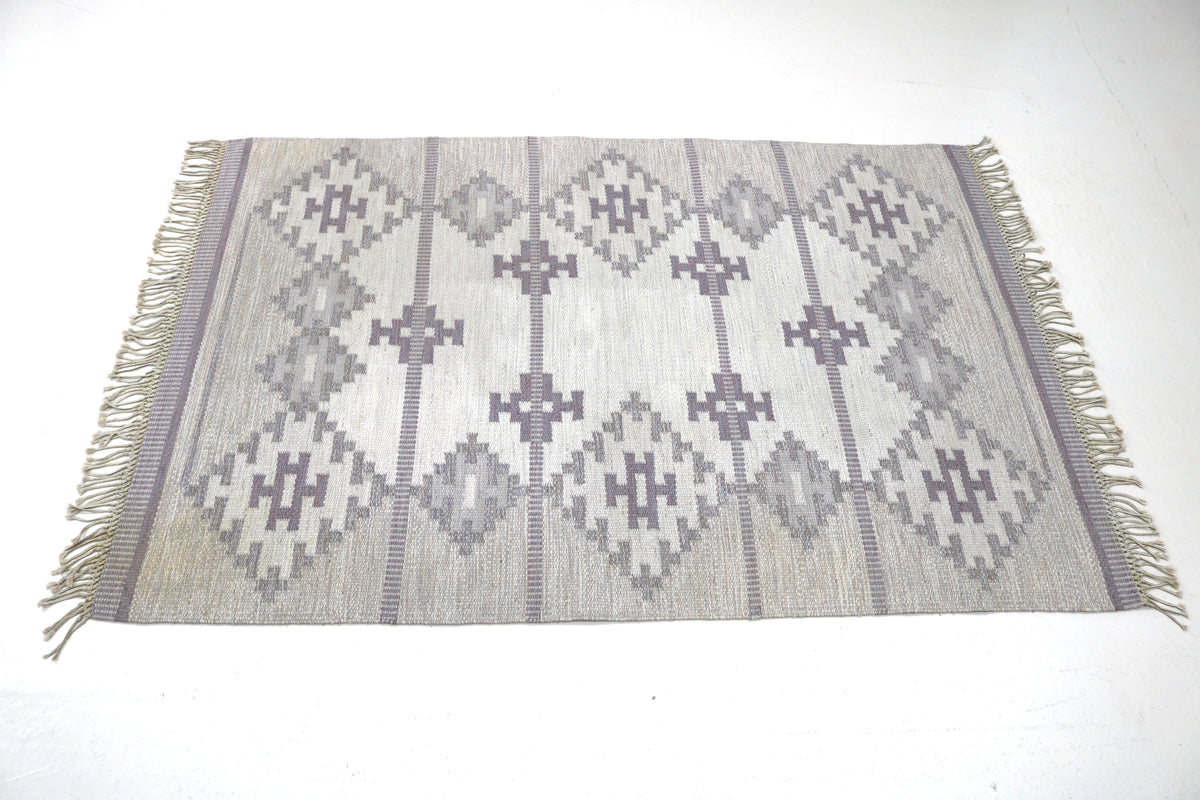 Full rug view highlighting symmetrical geometric composition and restrained muted tones
