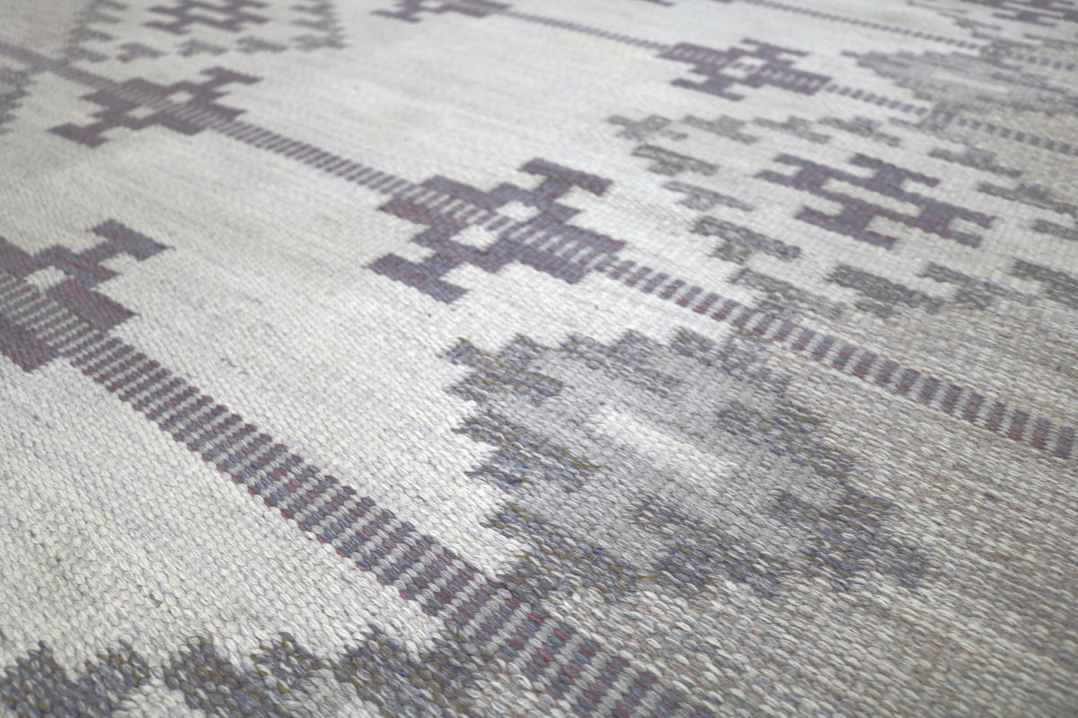 Close view featuring geometric diamond motifs arranged across the muted field