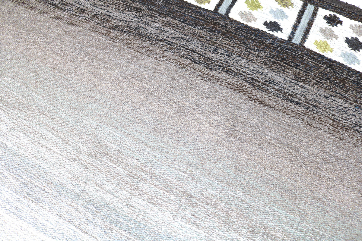 Detailed rug surface showing soft grey tones and delicate horizontal transitions