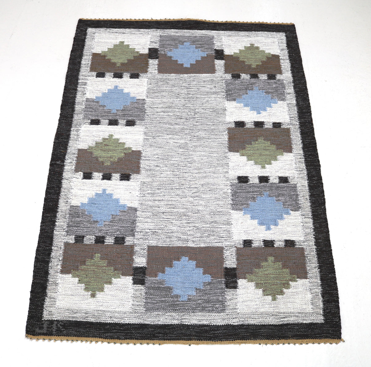 Vintage Swedish Kilim rug showcasing repeating geometric shapes across a soft grey field