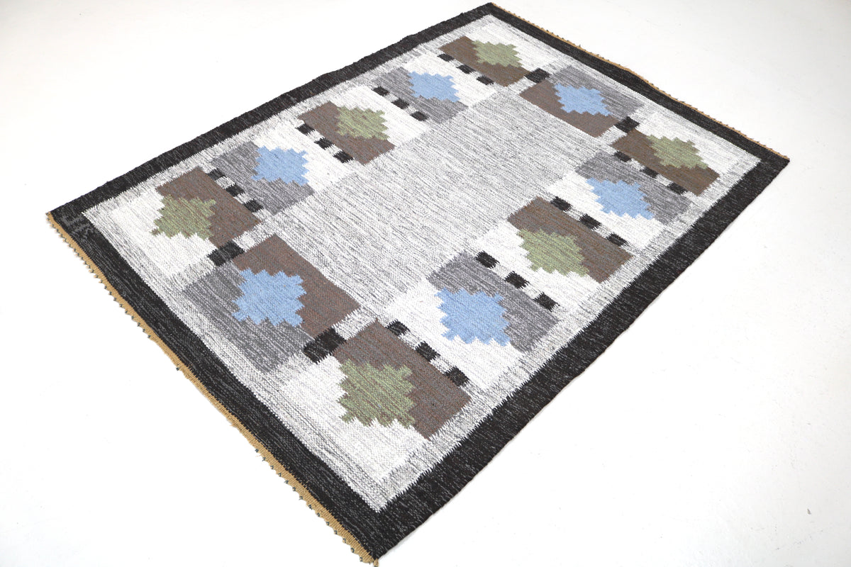 Full view of vintage Swedish Kilim rug with balanced geometric design and dark border