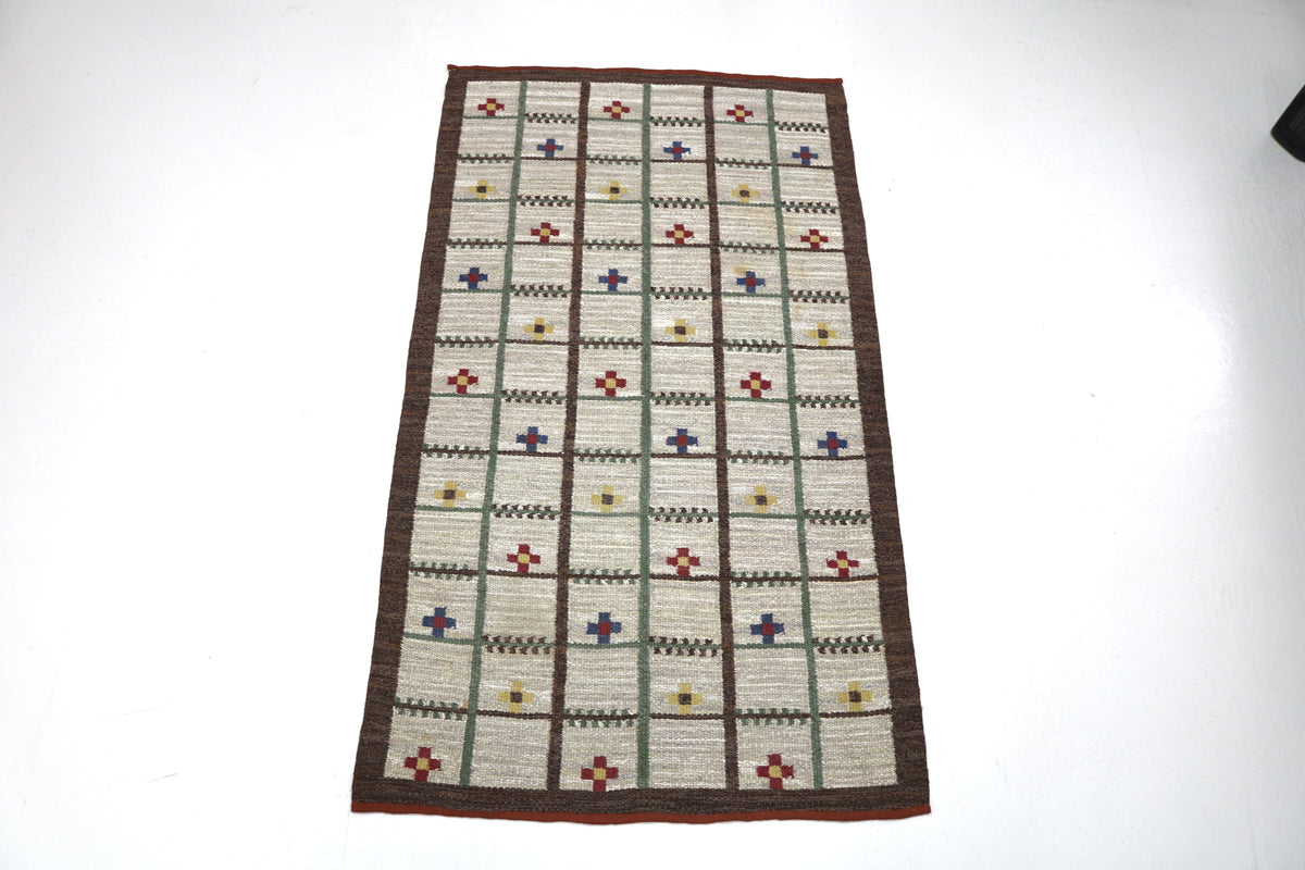 Full-length view of vintage Swedish Kilim rug highlighting its long rectangular lattice composition
