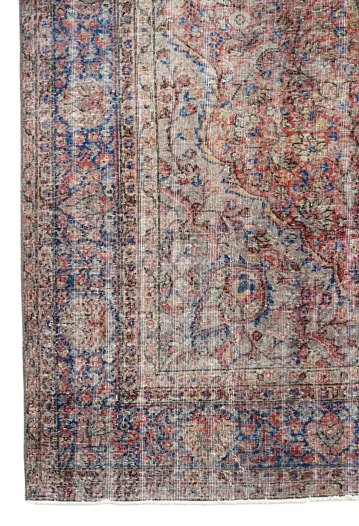 Vintage Turkish carpet with faded central medallion, red and blue tones, and warm neutral accents