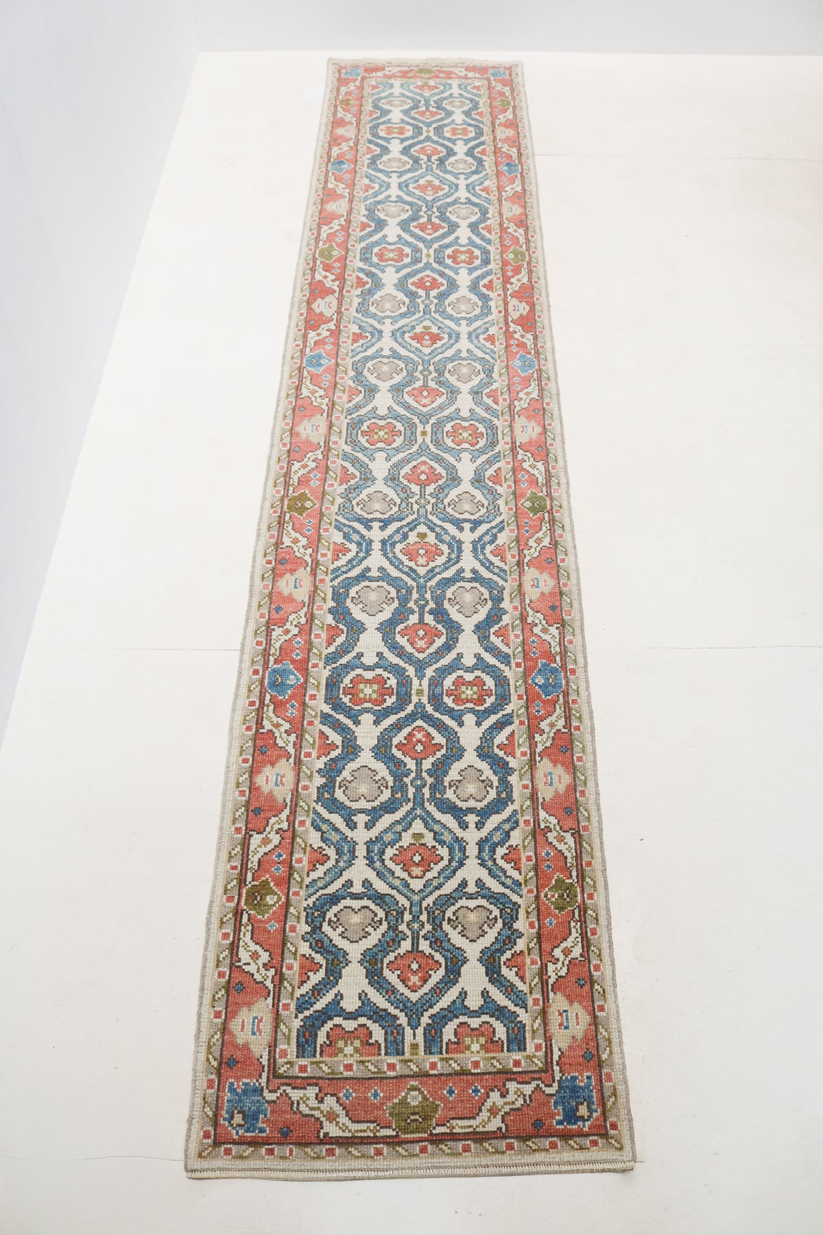 Close-up of vintage Turkish Ushak Runner showing coral red and blue border