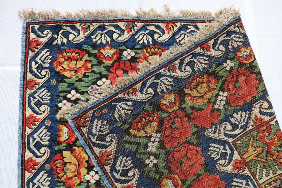 Folded Zeichur runner showing the richly decorated field, floral border and woven reverse side