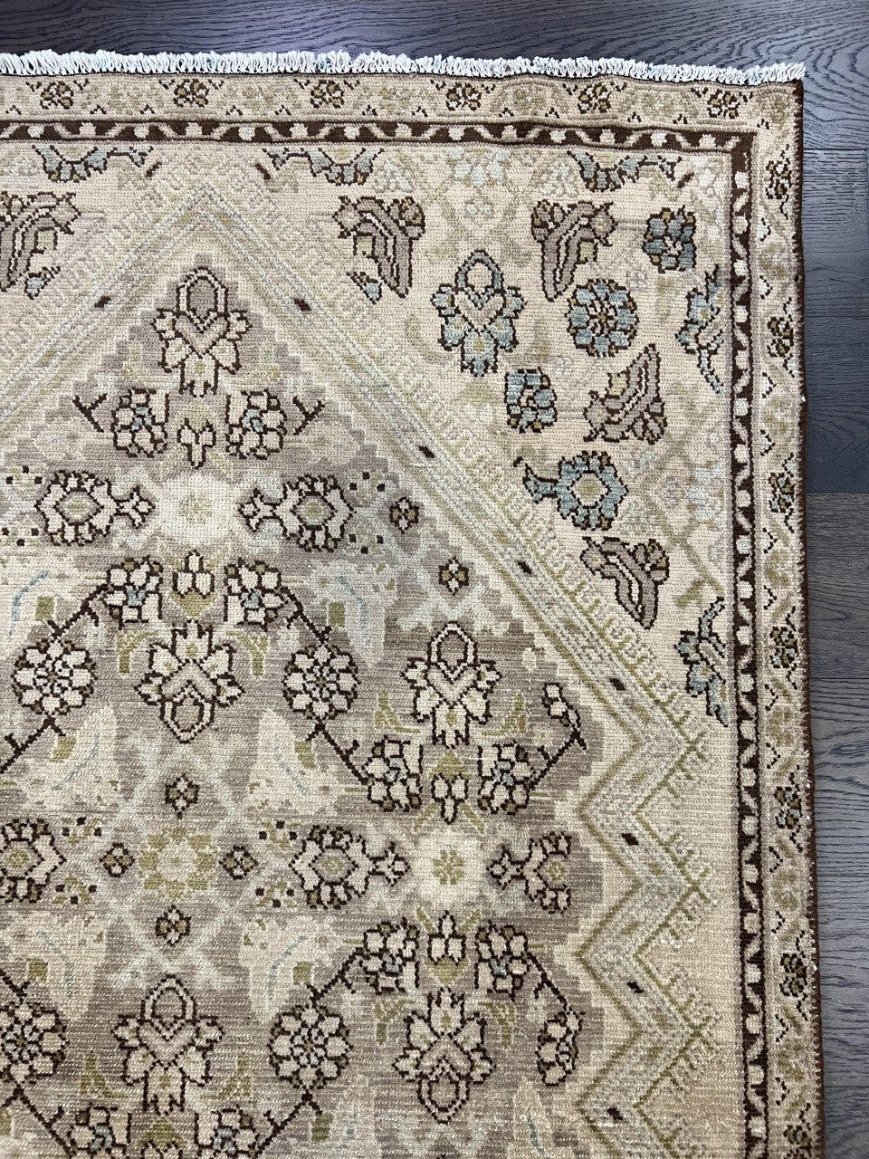 Detailed rug section showing floral clusters and geometric border patterns