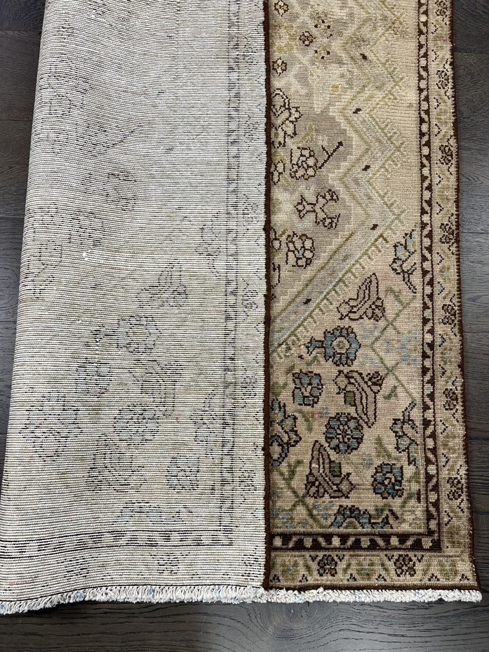 Folded Malayer rug showing patterned reverse and woven texture