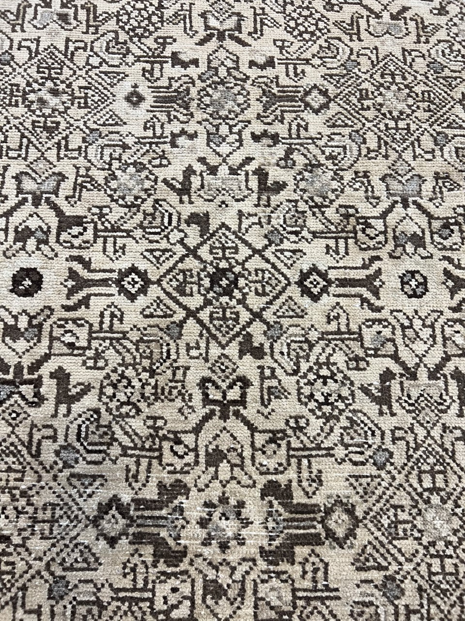 Detailed rug section showing repeating floral patterns across a muted field