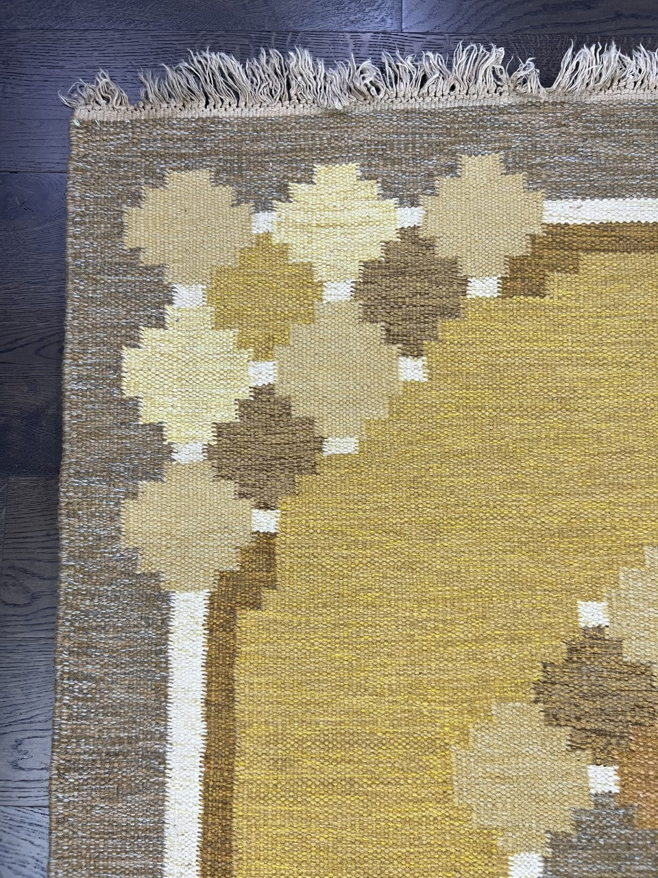 Close-up of Swedish Kilim featuring layered diamond motifs in cream, grey and ochre