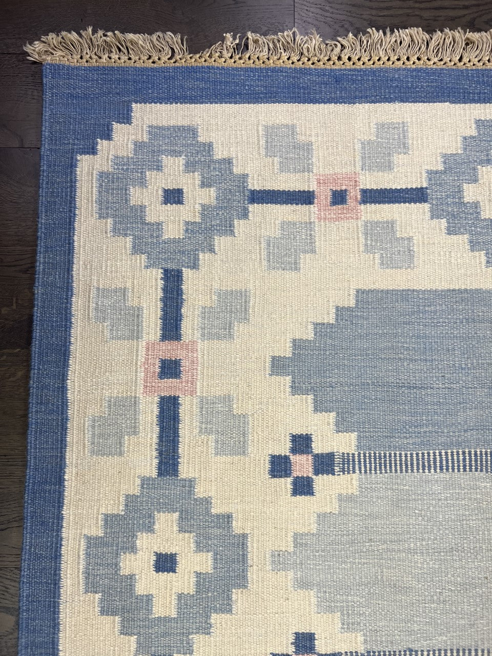 Close-up of Swedish Kilim with diamond motifs and subtle pink geometric details