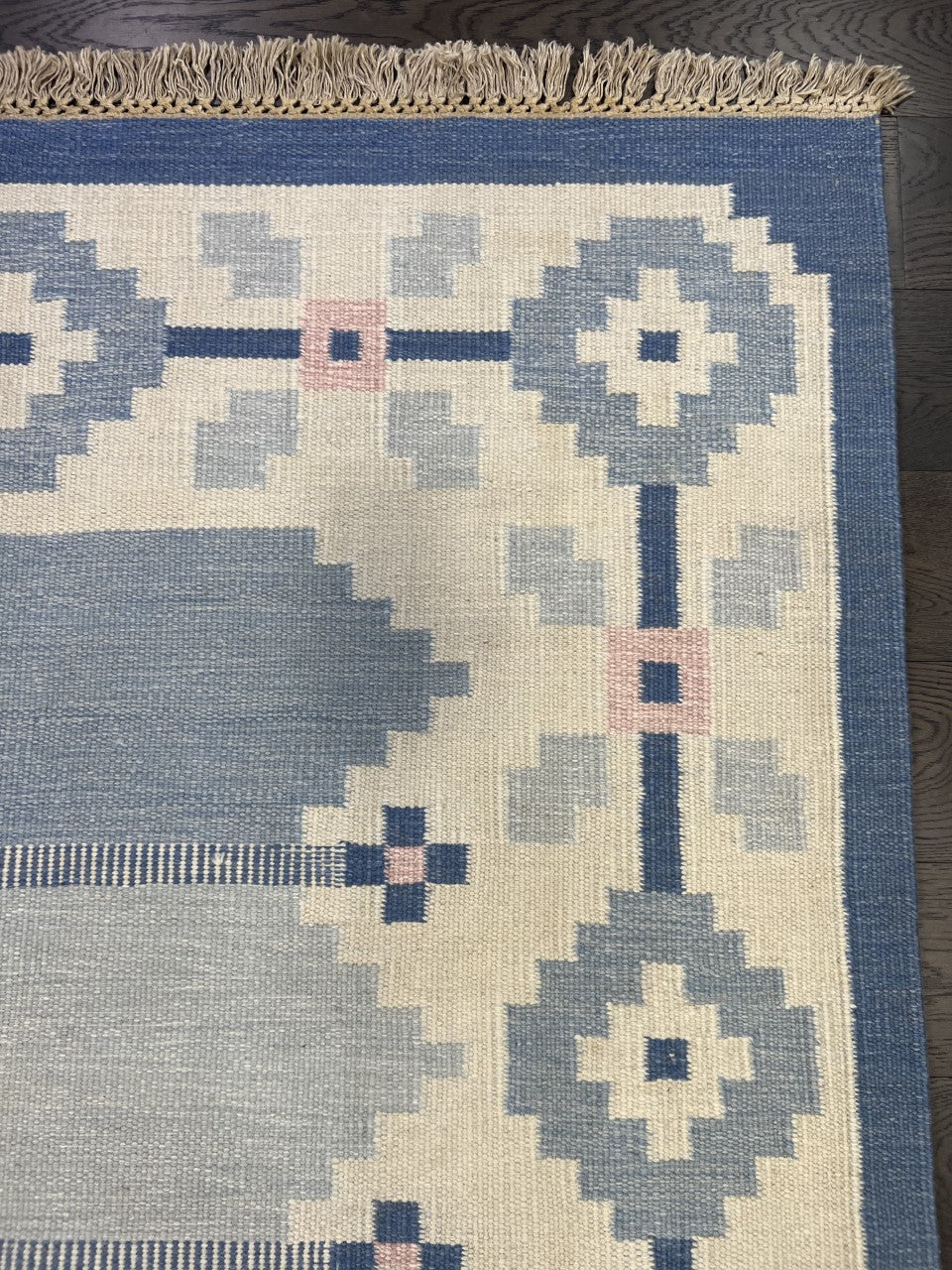 Detailed Kilim section featuring blue geometric shapes and cream patterned borders