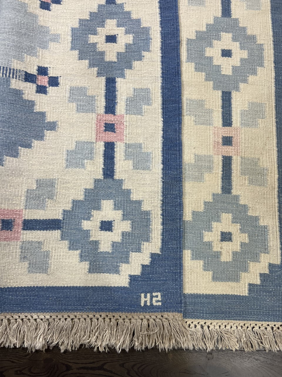 Close-up showing geometric patterns in blue, cream and muted pink tones