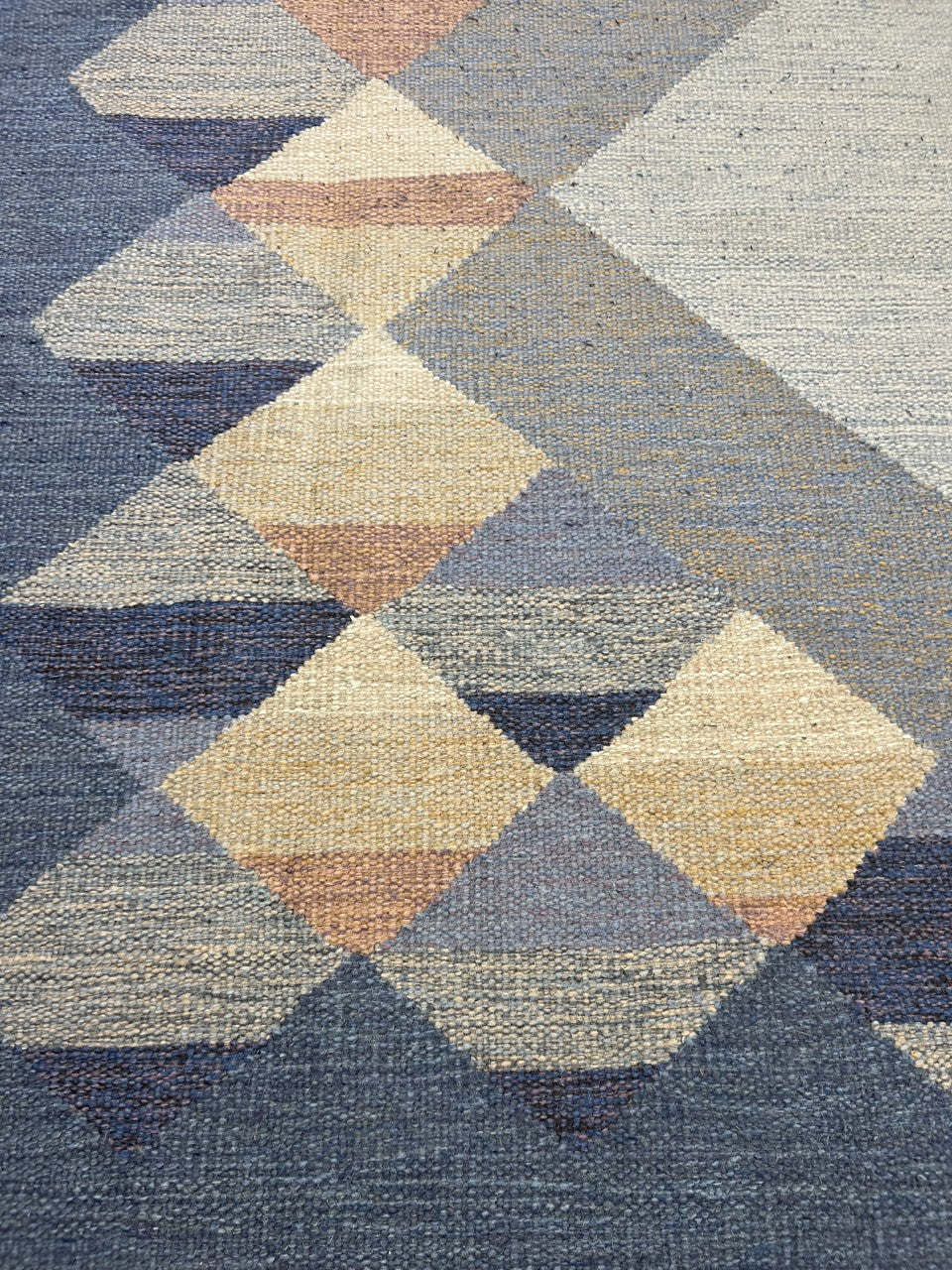 Close-up showing geometric motifs and subtle colour transitions across the blue field