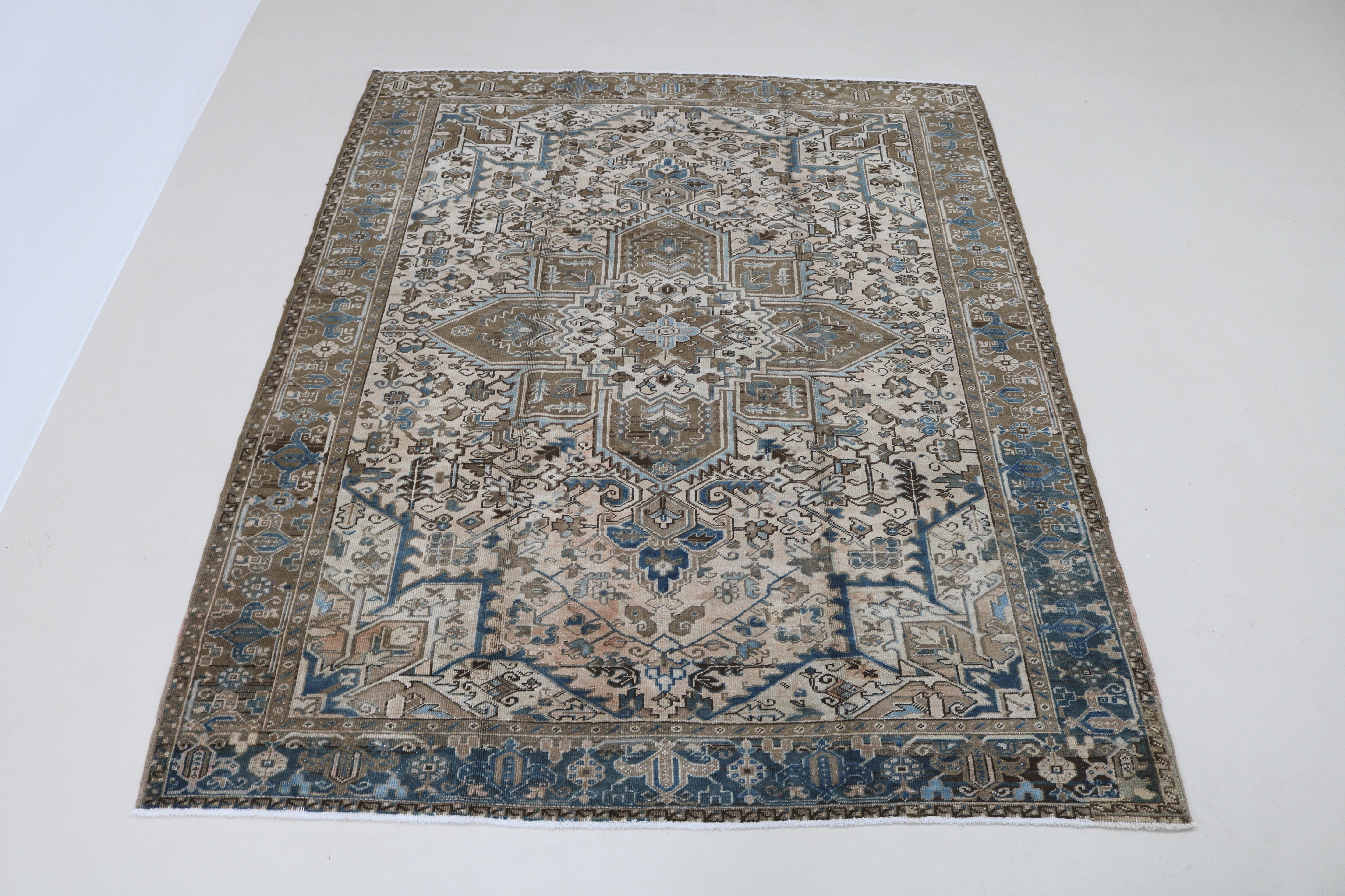 Full view of decorative antique Heriz carpet with bold geometric design
