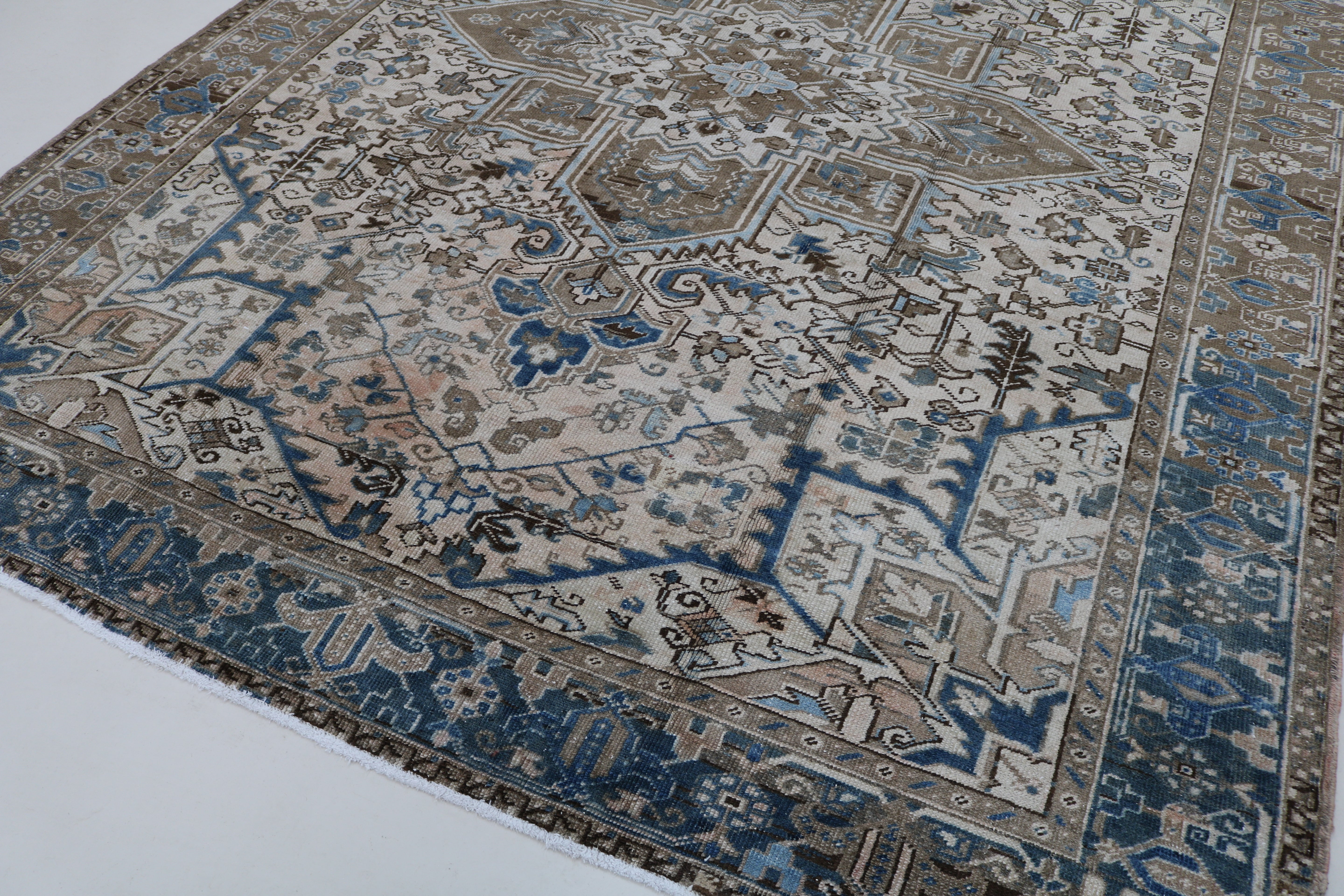 Close-up of hand-knotted wool texture on decorative antique Heriz carpet
