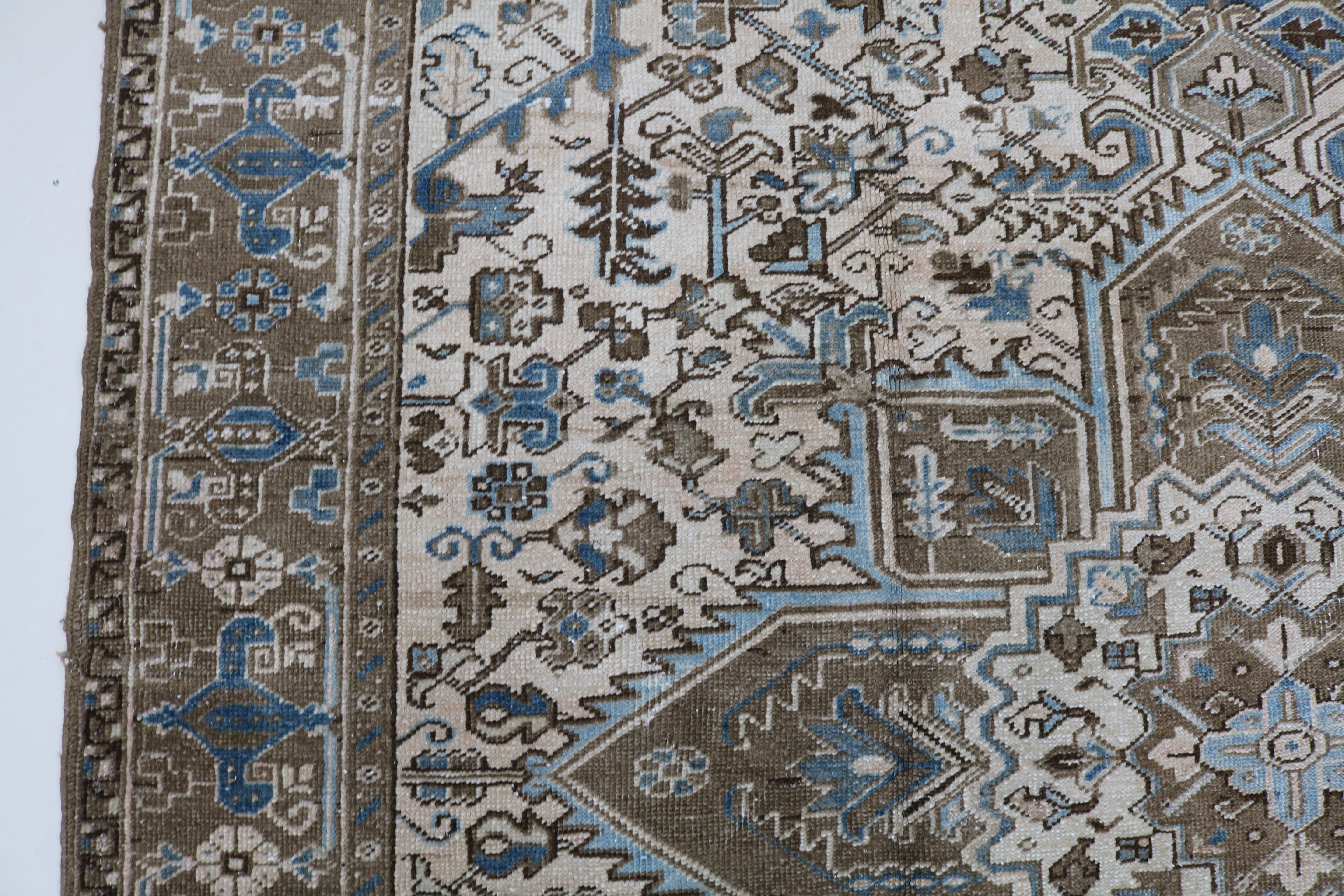Close-up of hand-knotted wool texture on decorative antique Heriz carpet
