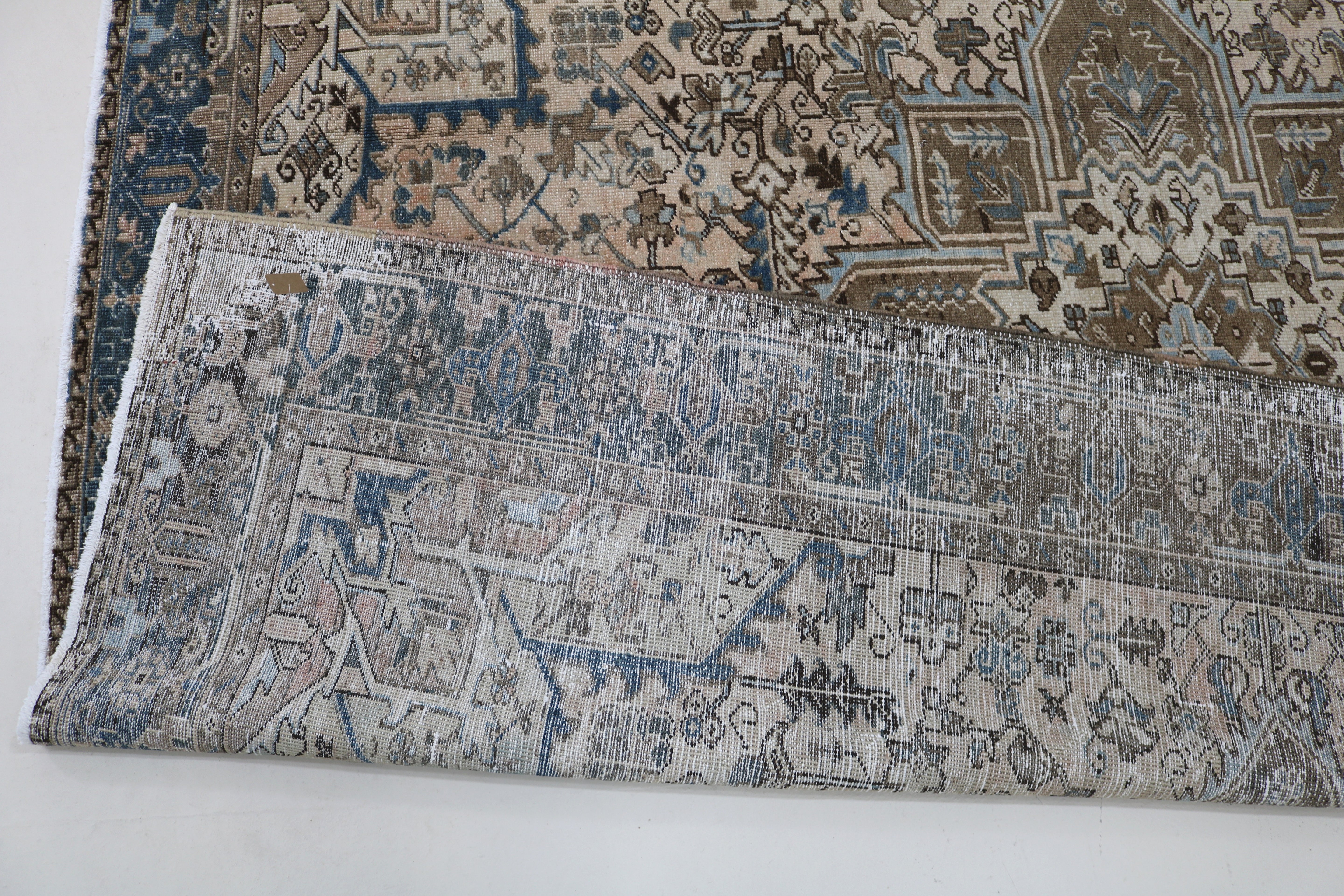 Close-up of hand-knotted wool texture on decorative antique Heriz carpet
