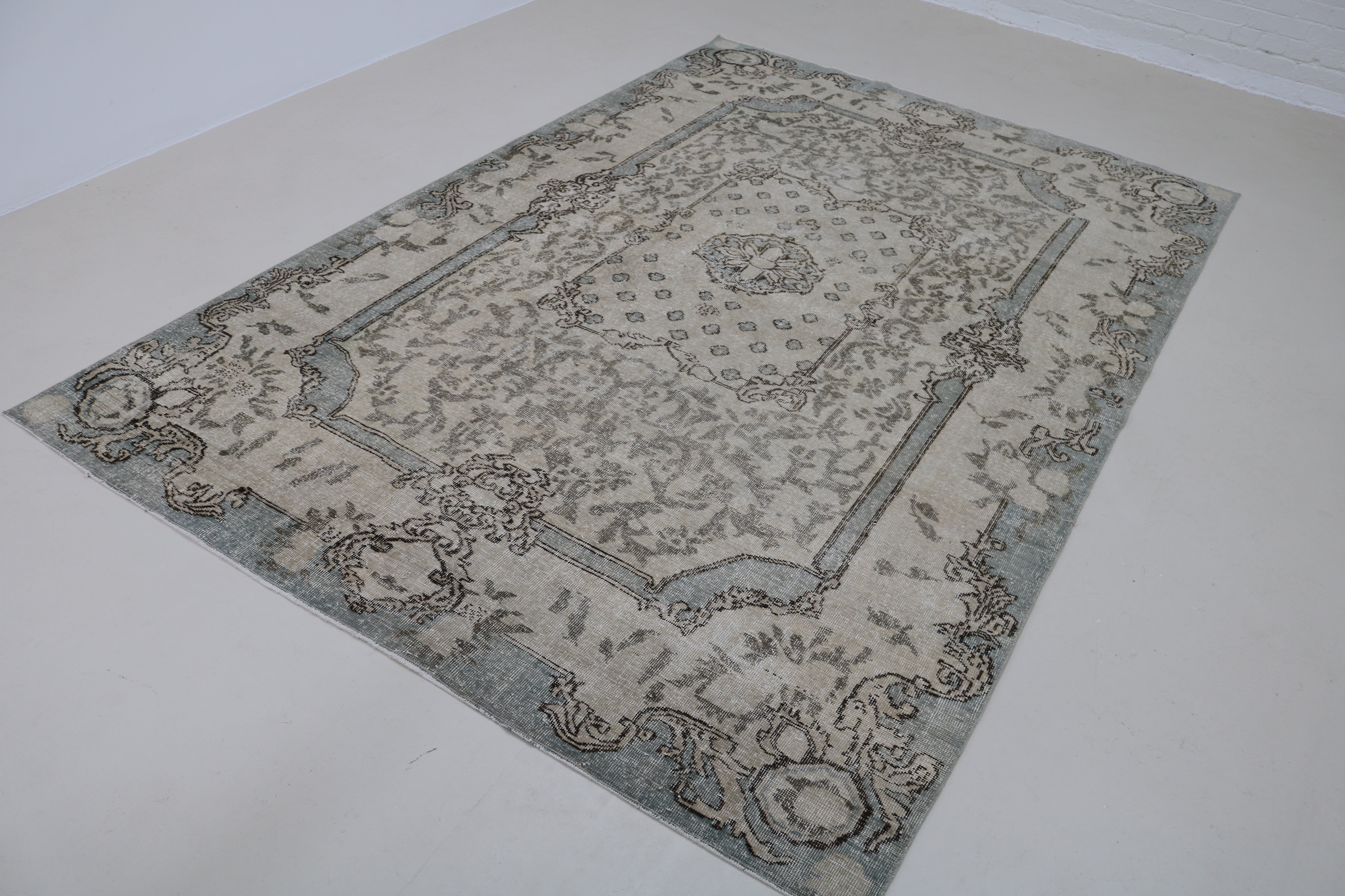 Angled view of vintage Turkish Sparta rug showing field and border details
