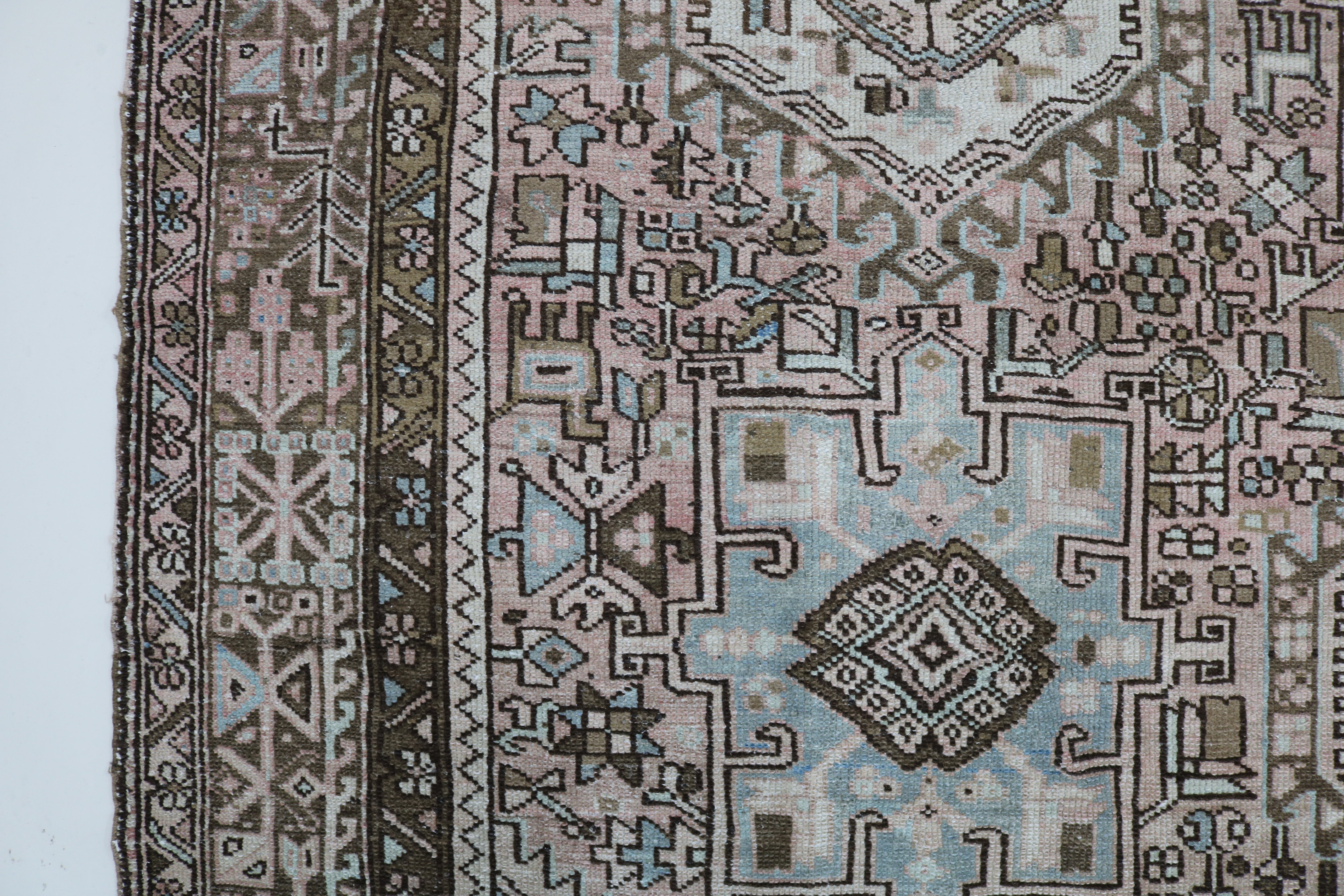 Close-up of hand-knotted wool texture on antique Persian Heriz–Karaja carpet
