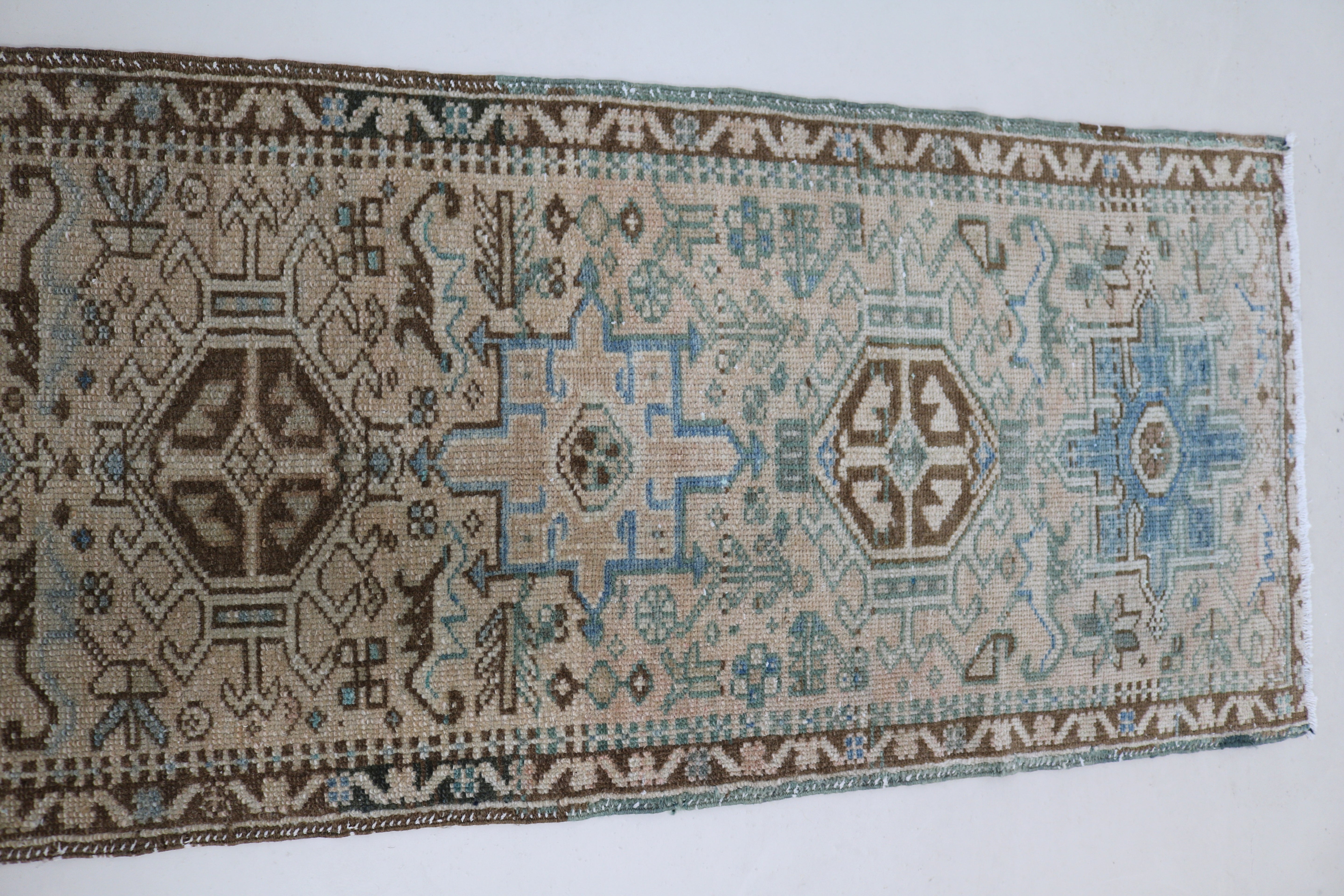 Close-up of hand-knotted wool texture on antique Persian Heriz runner

