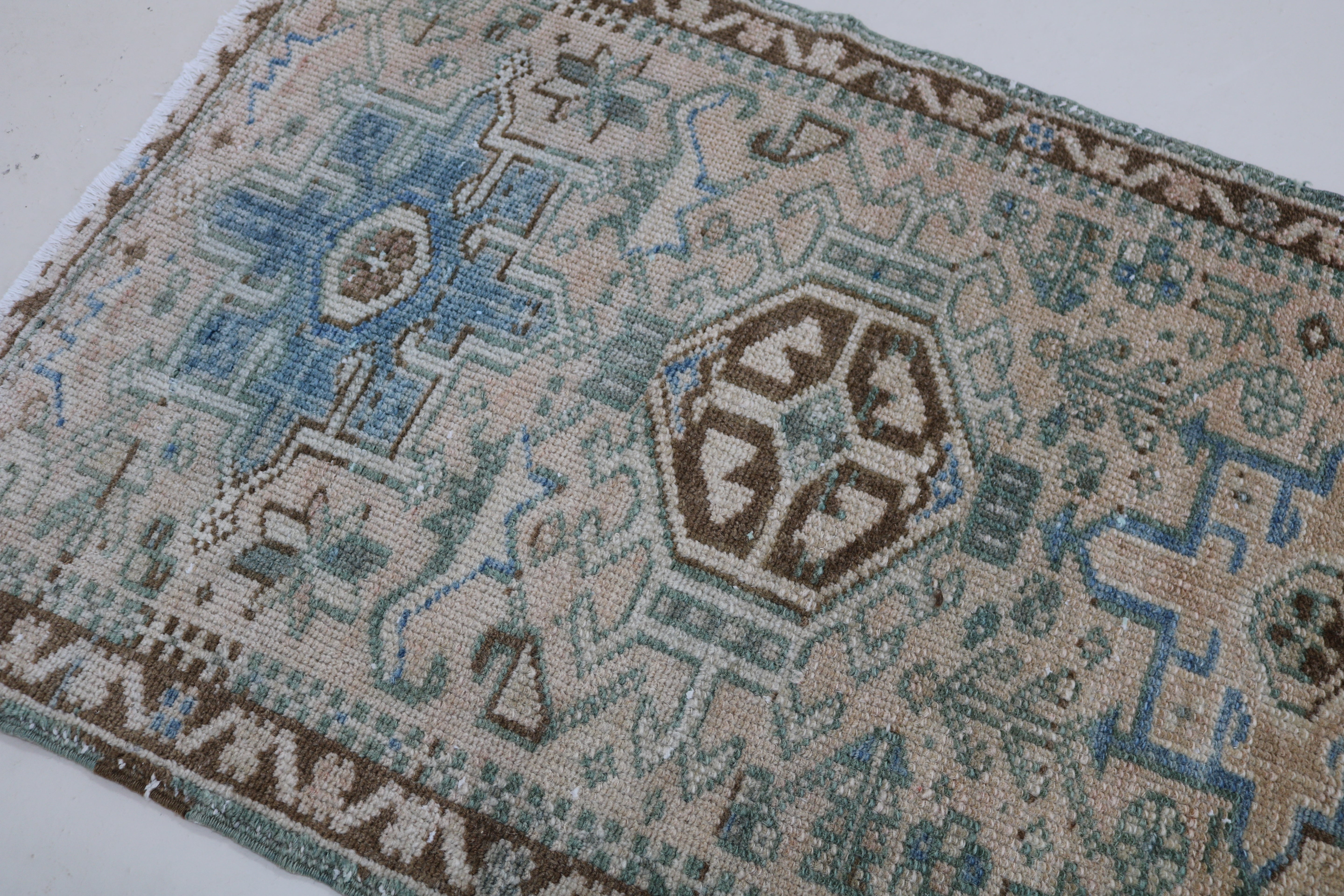 Close-up of hand-knotted wool texture on antique Persian Heriz runner
