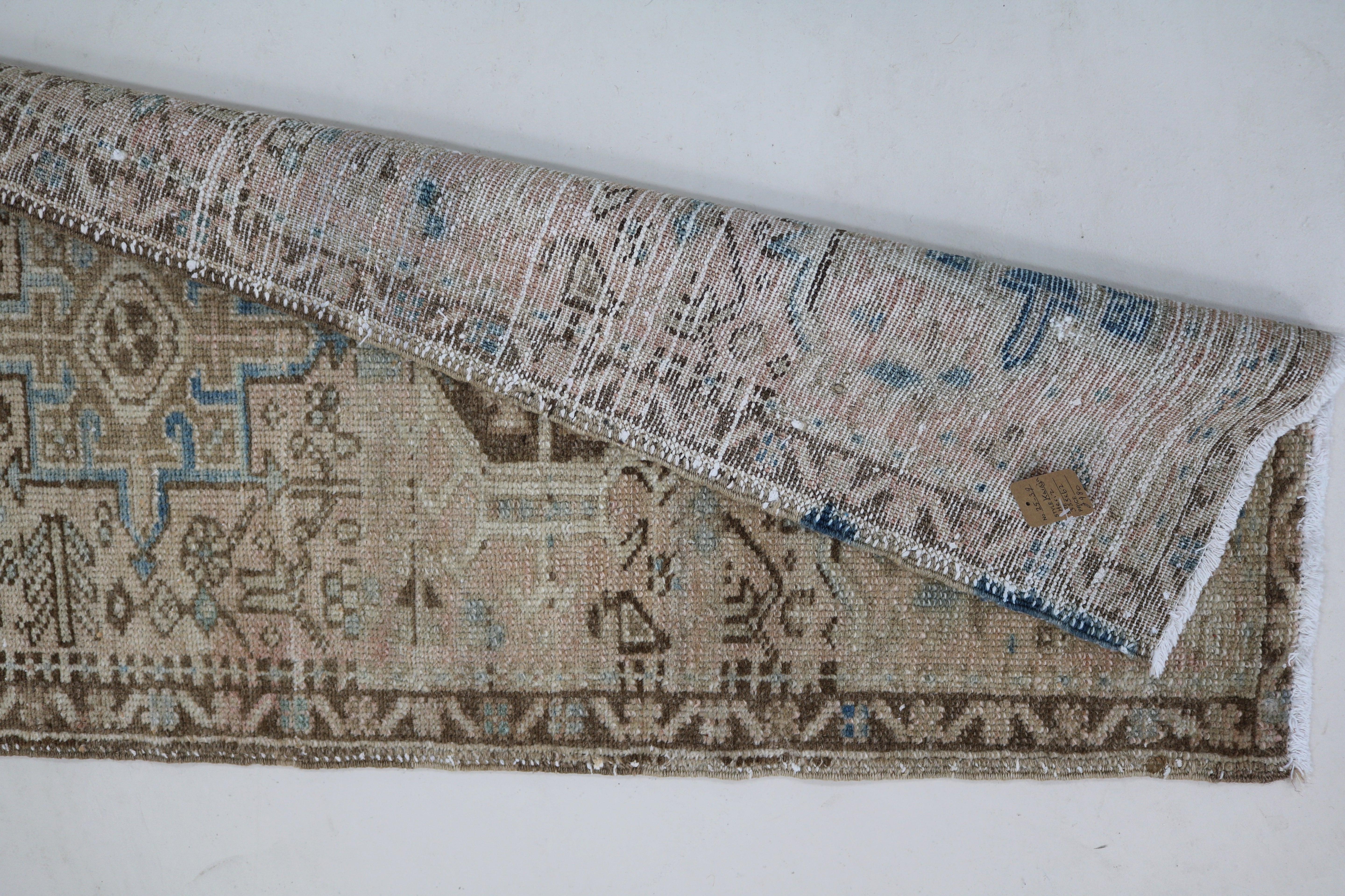 Close-up of hand-knotted wool texture on antique Persian Heriz runner
