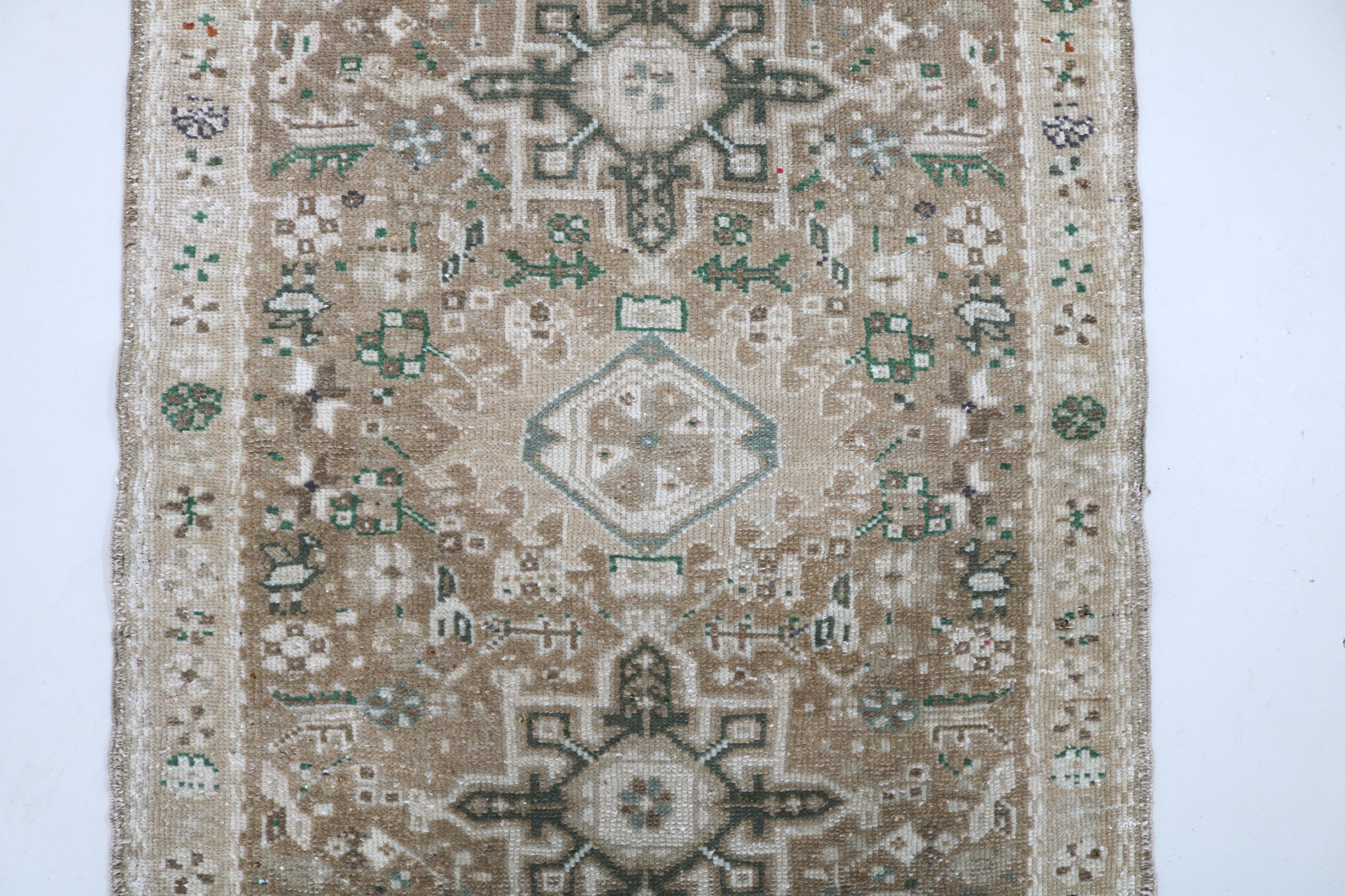 Close-up of hand-knotted wool texture on antique Persian Heriz runner
