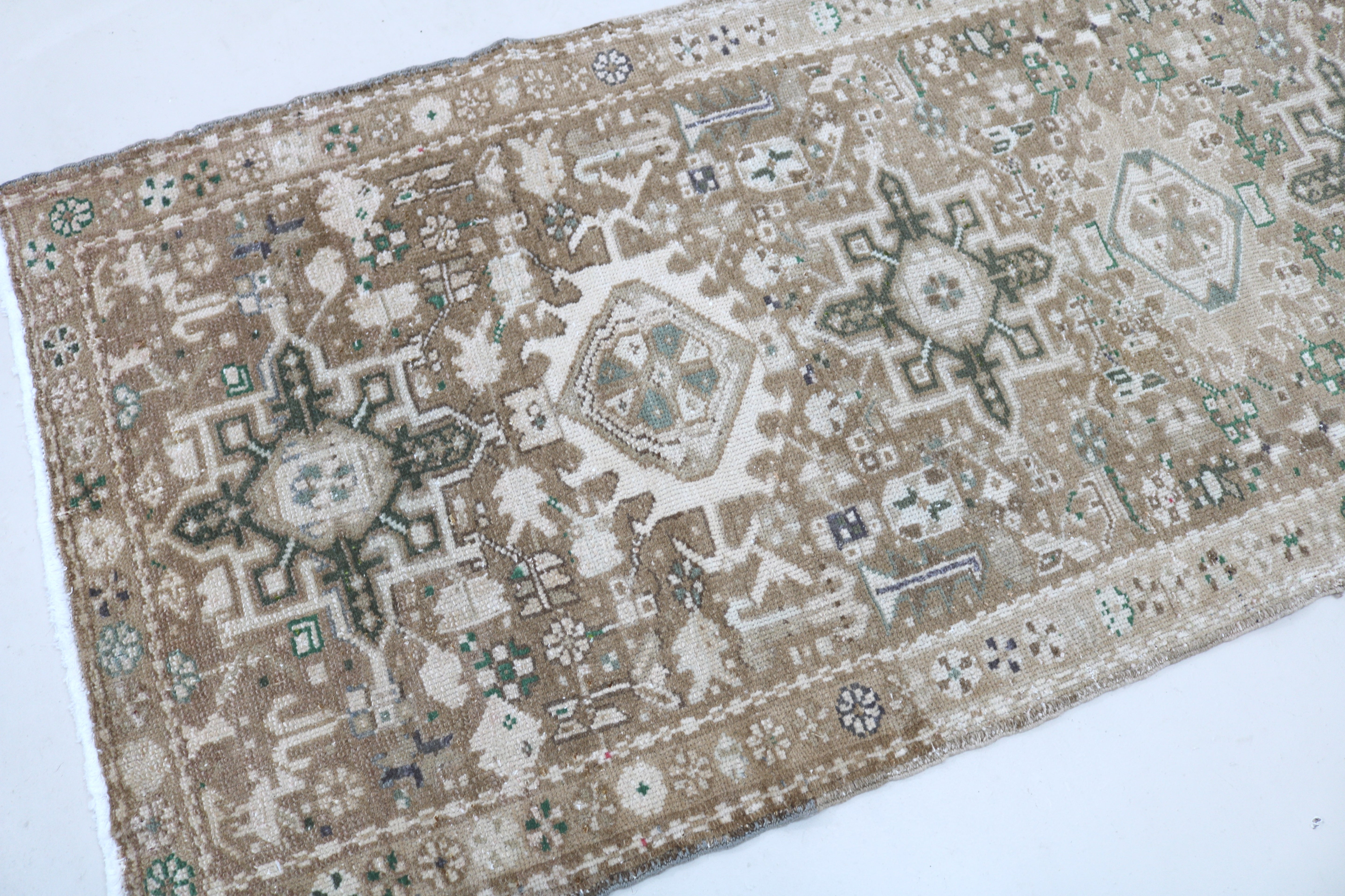 Close-up of hand-knotted wool texture on antique Persian Heriz runner
