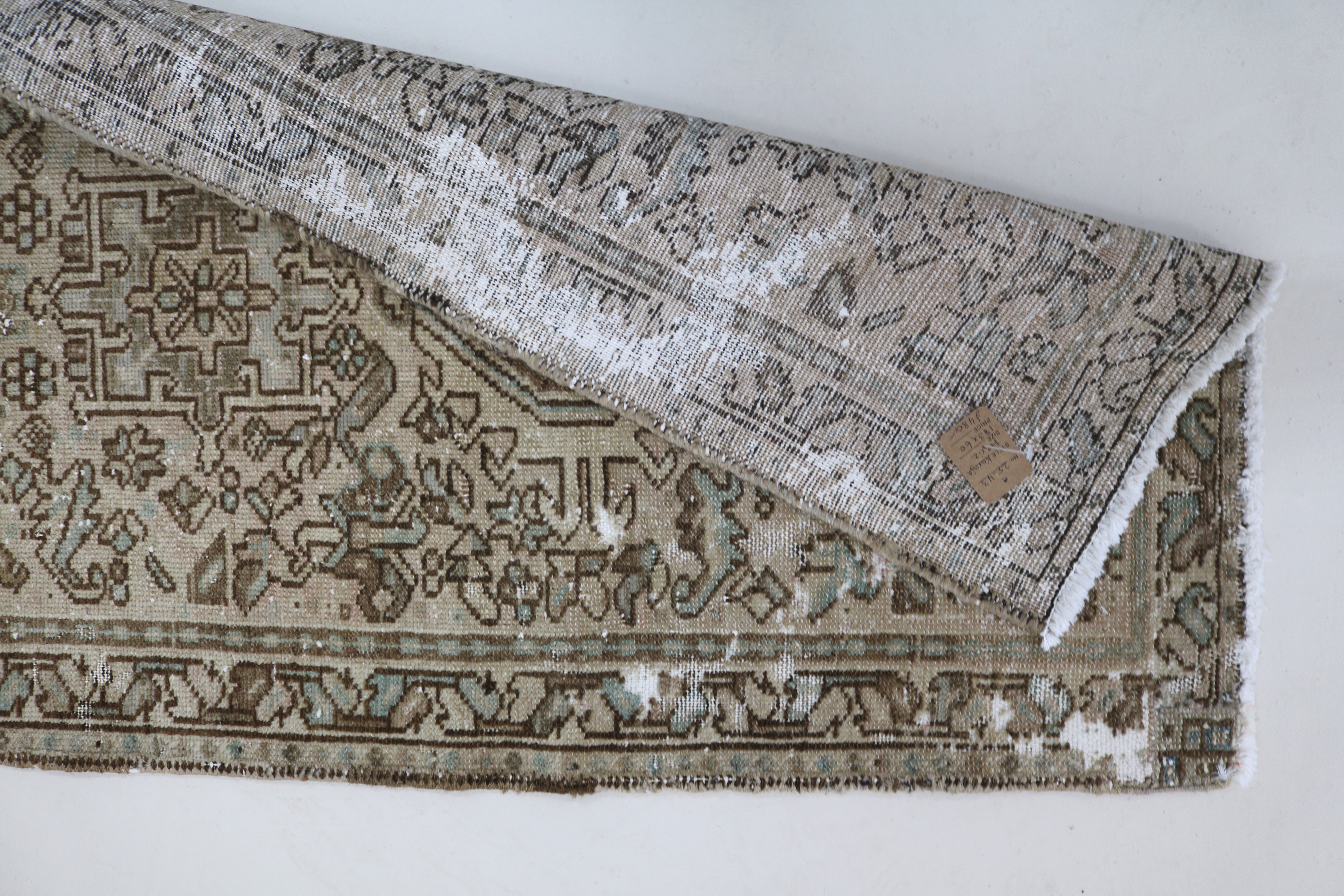 Perspective view of antique Persian Heriz runner on floor
