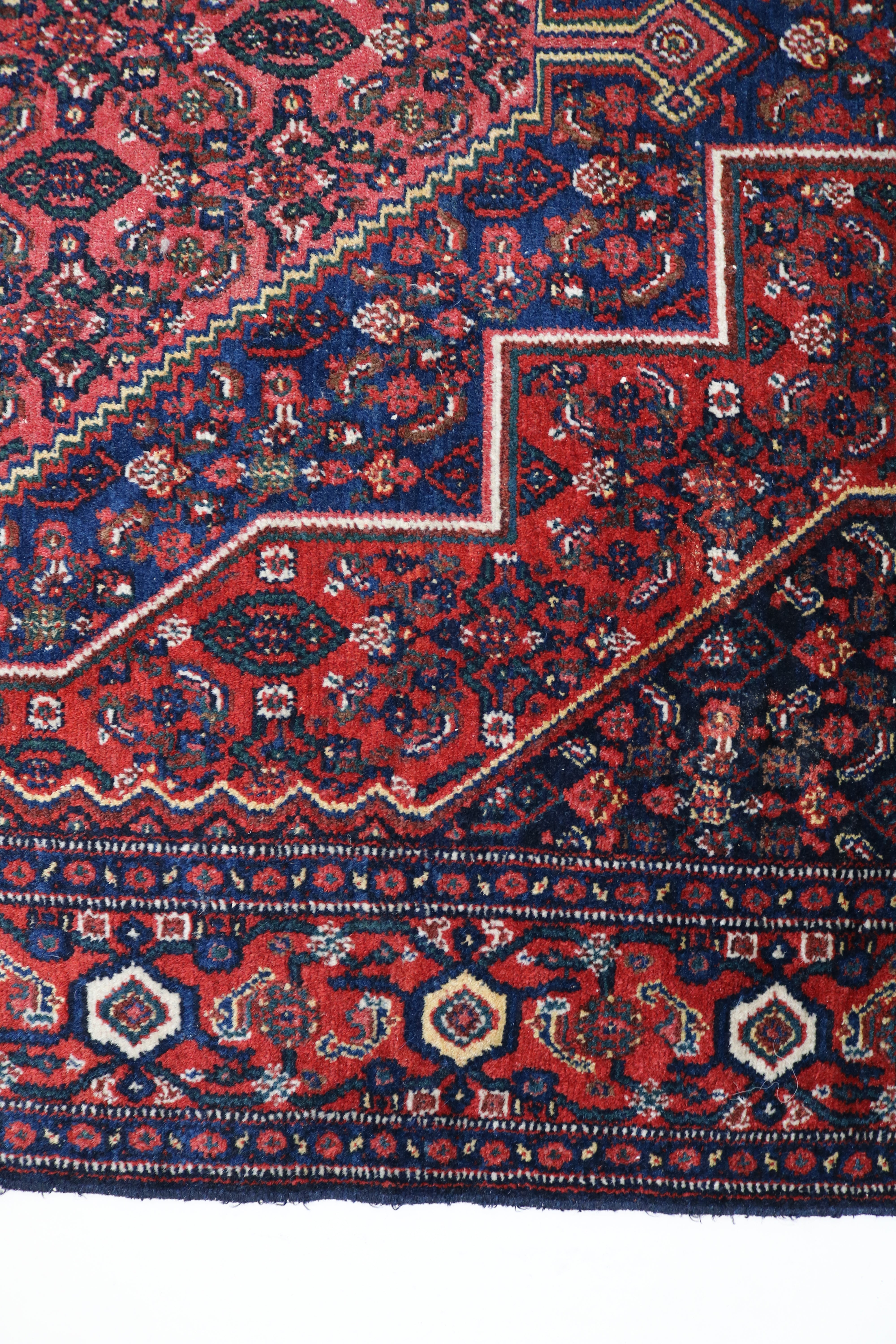 Close-up of hand-knotted wool texture on antique Persian Senneh rug
