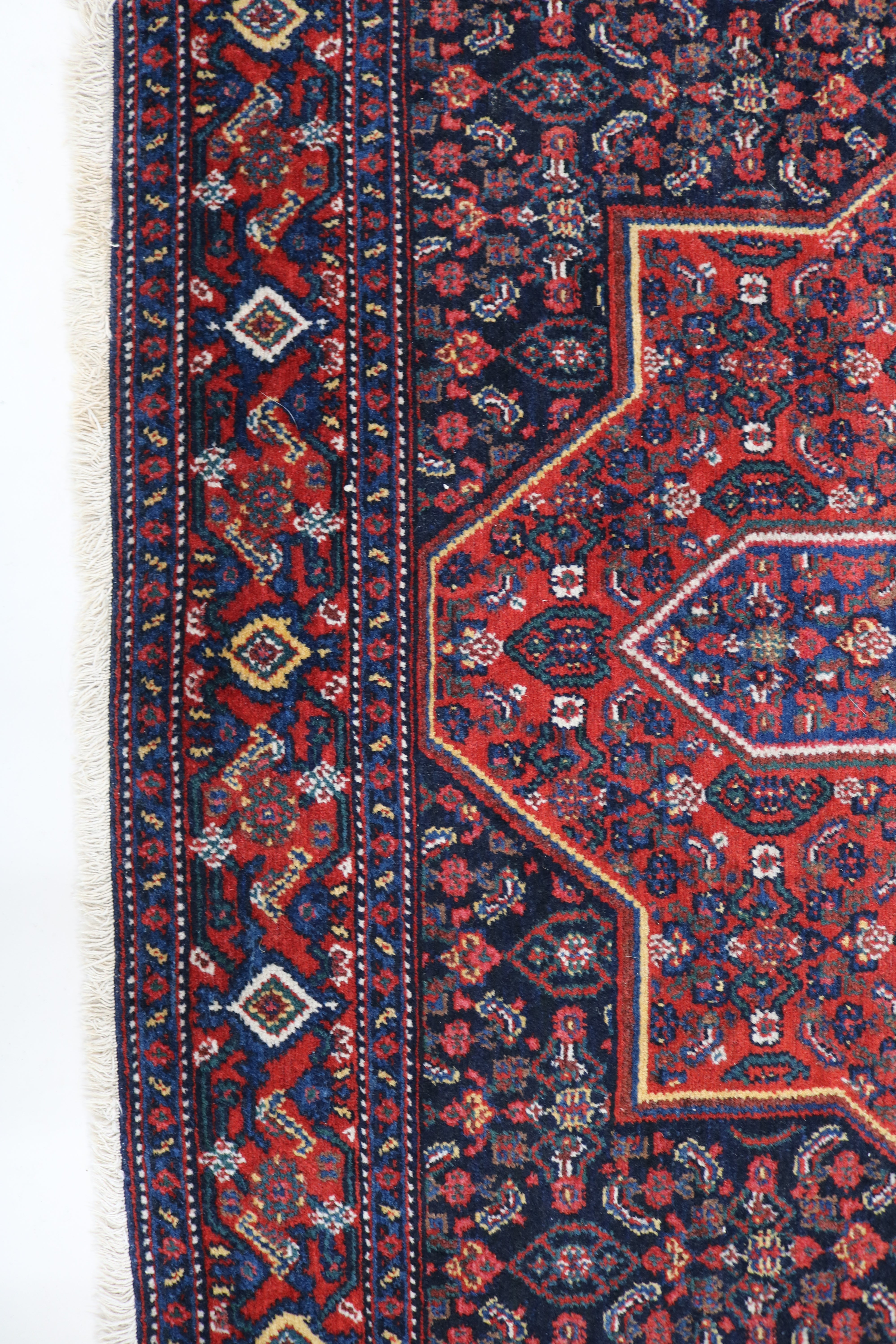 Close-up of hand-knotted wool texture on antique Persian Senneh rug
