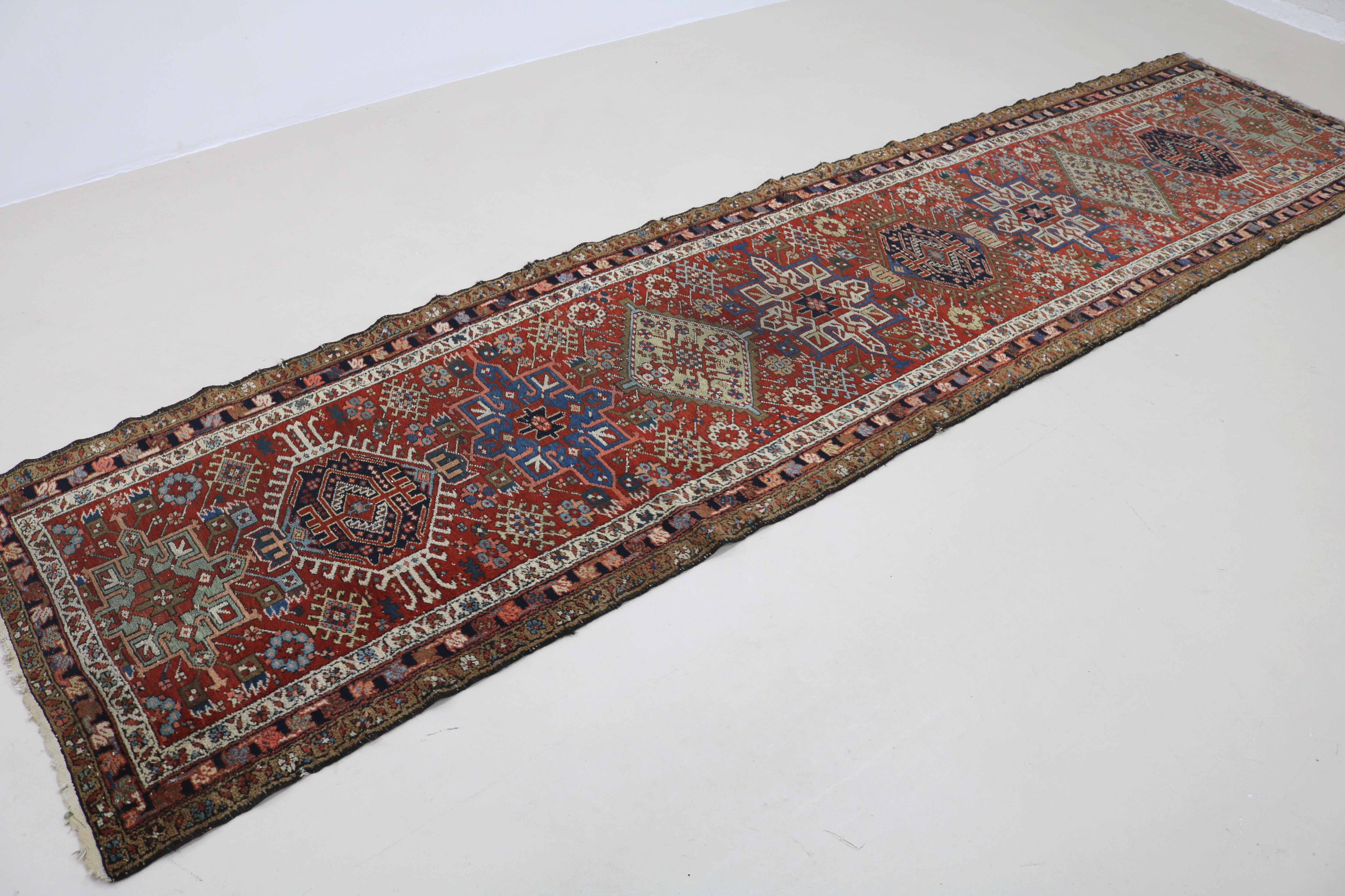 Angled view of antique Persian Karaja runner showing field and borders
