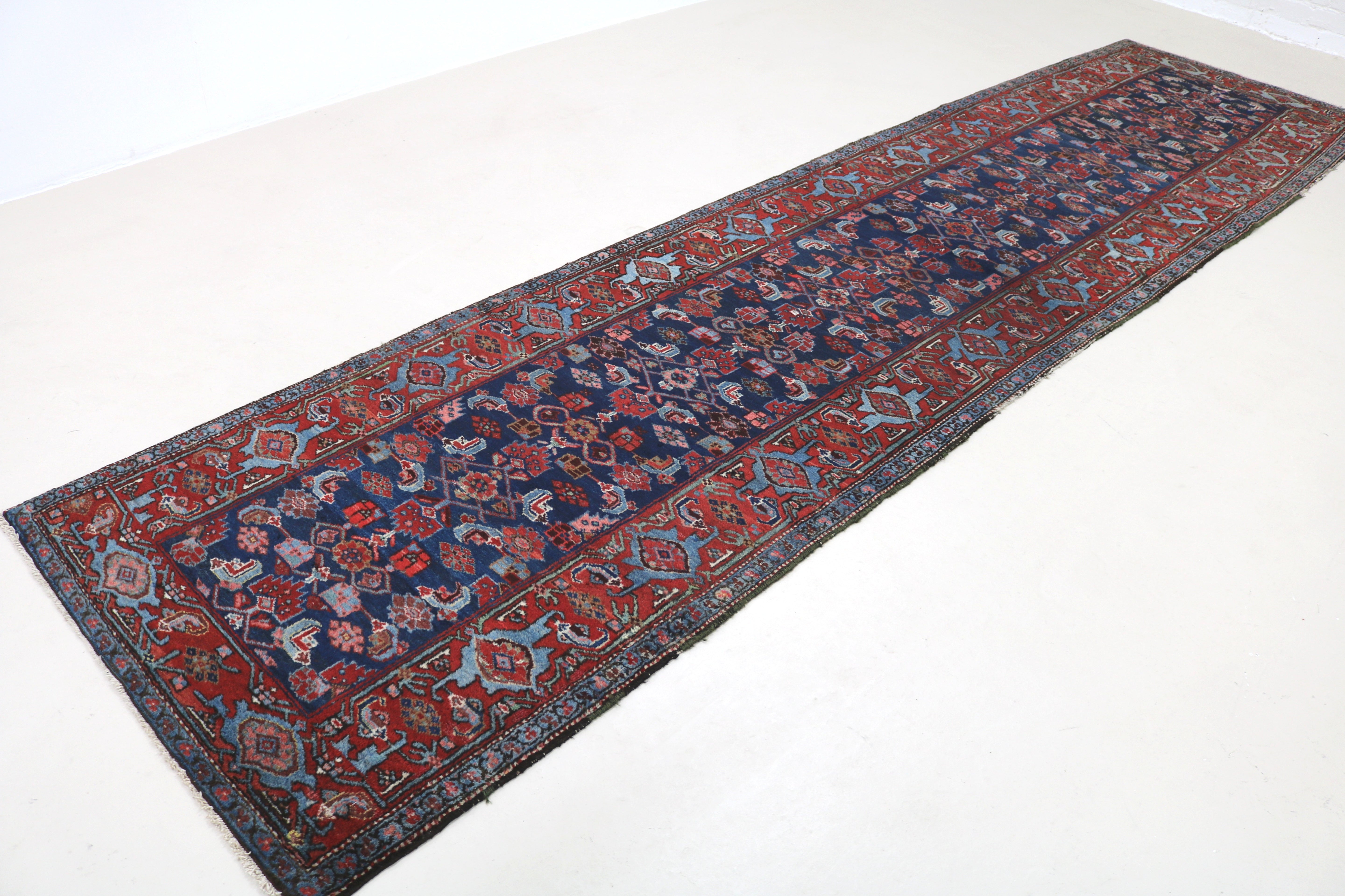 Angled view of antique Persian Malayer runner showing field and borders
