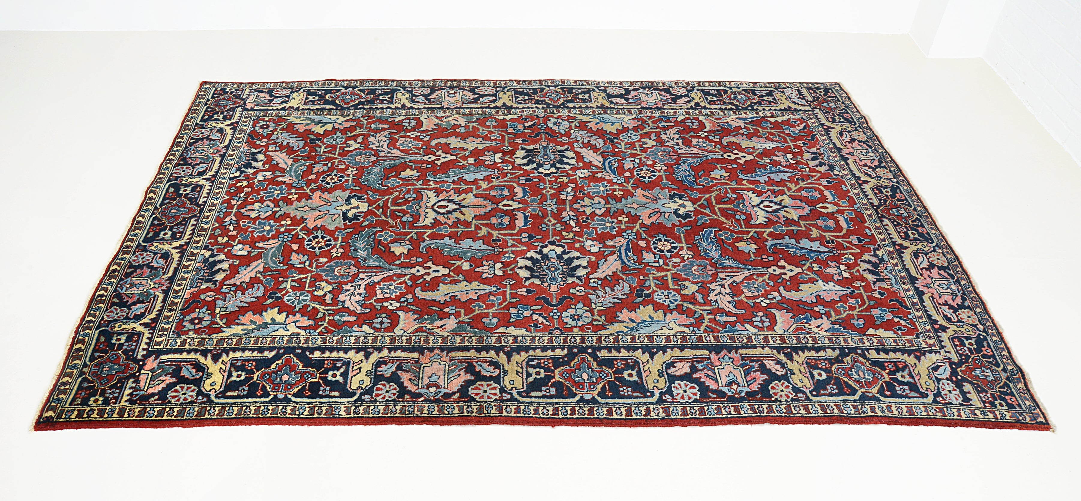 Hand-knotted antique Heriz carpet with rich red field and all-over floral design
