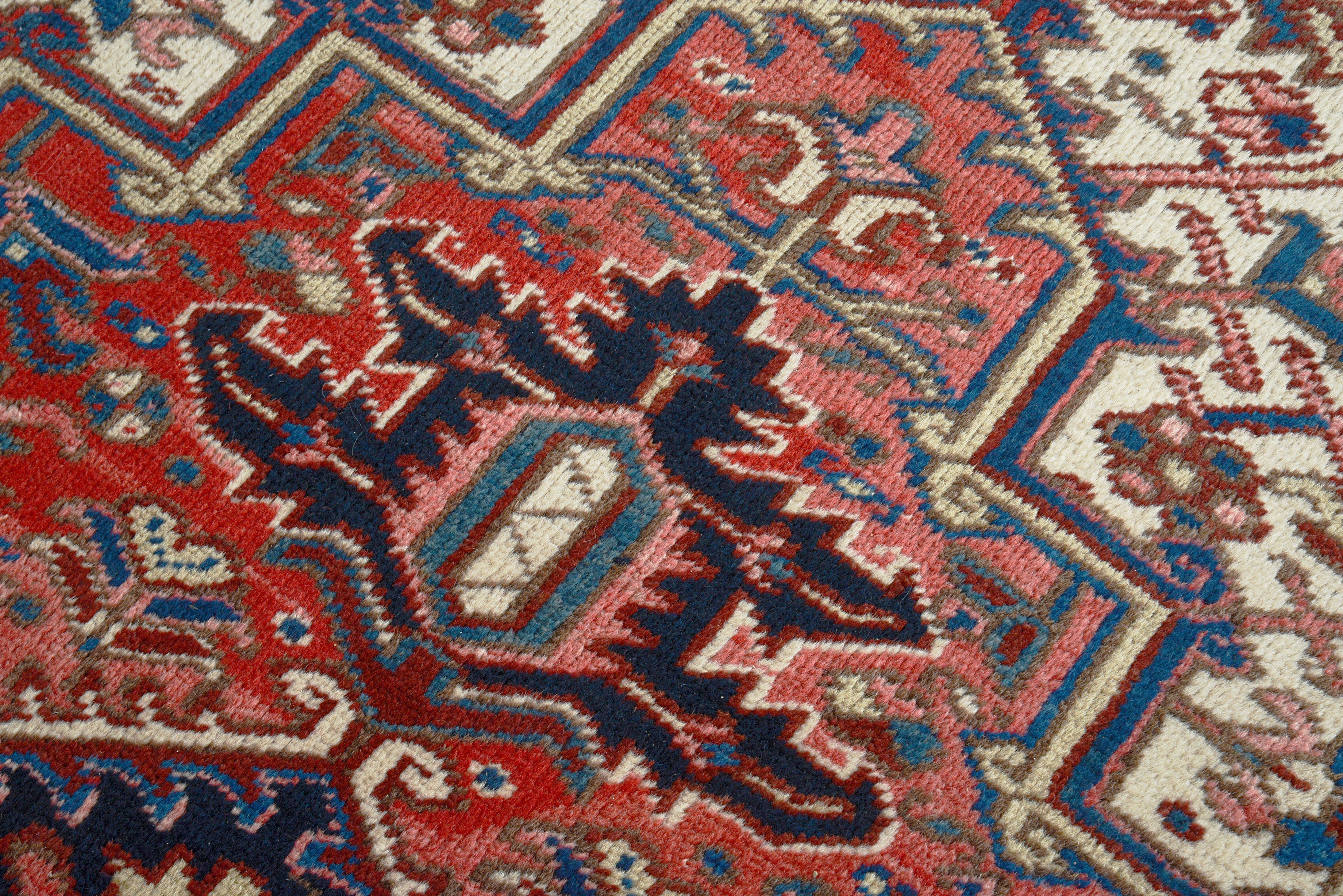 Close-up details of vintage Heriz carpet showing wool texture, motifs, and natural patina
