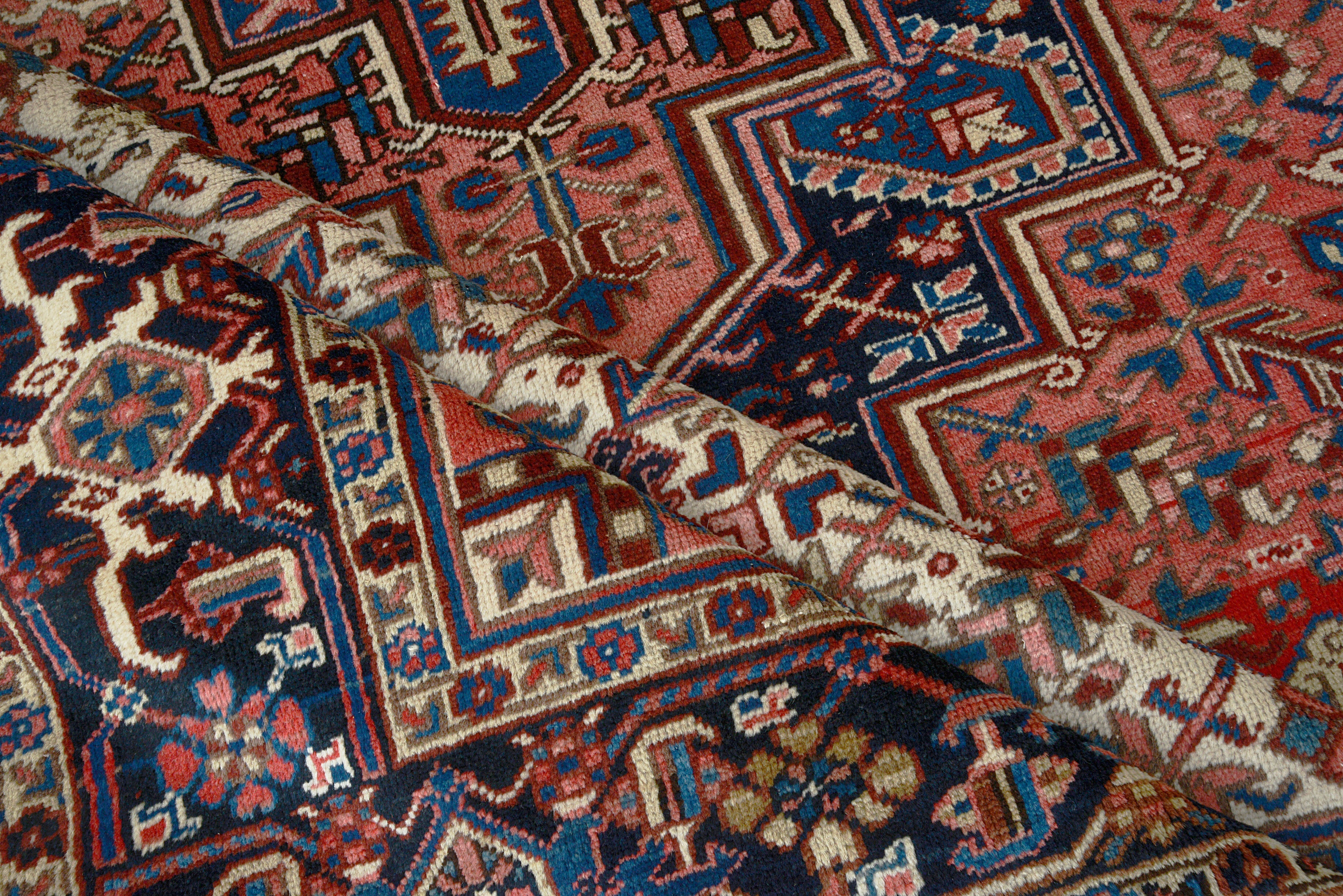 Close-up details of vintage Heriz carpet showing wool texture, motifs, and natural patina
