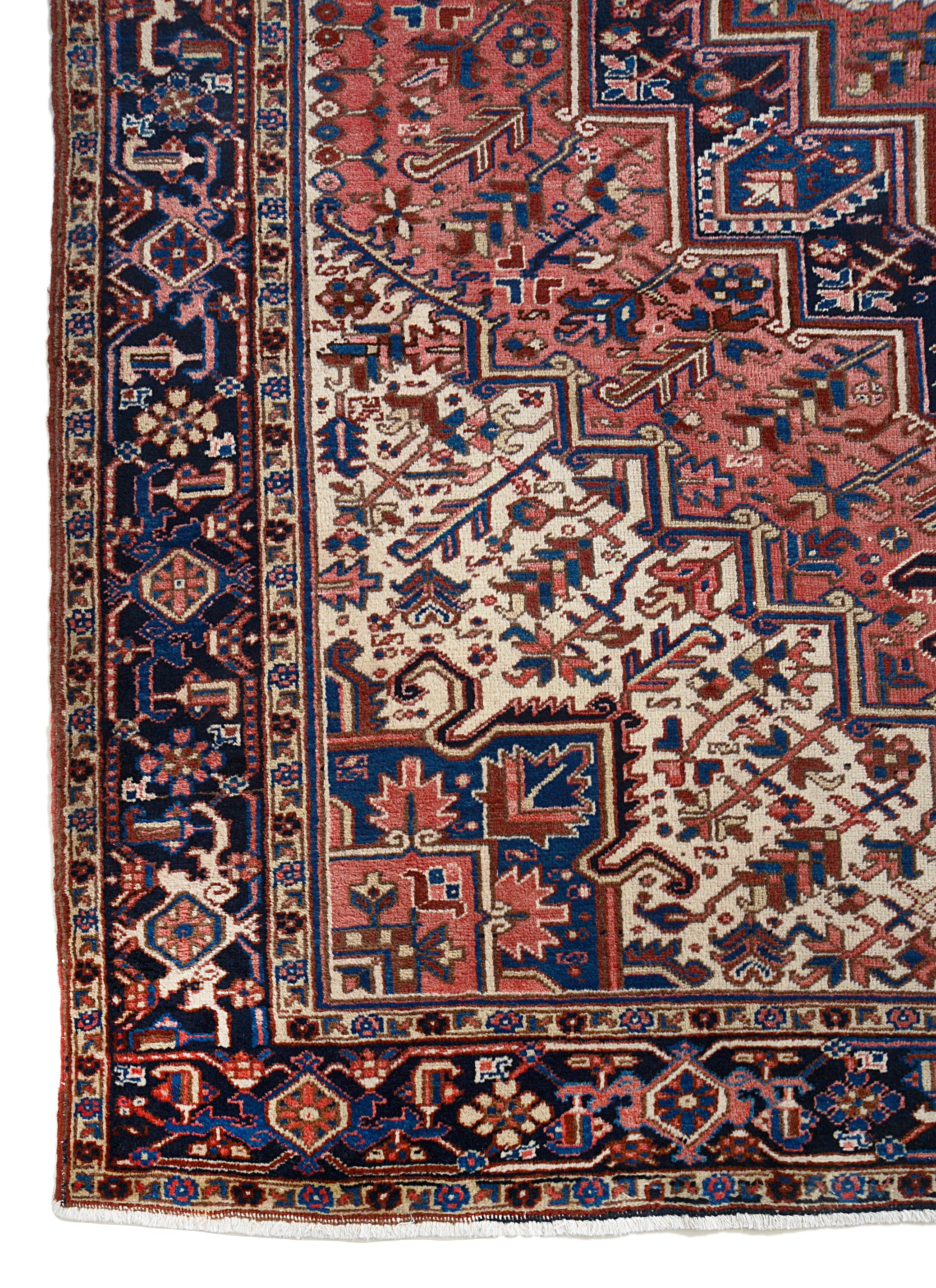 Vintage Heriz carpet corner detail showing hand-knotted wool and geometric border pattern

