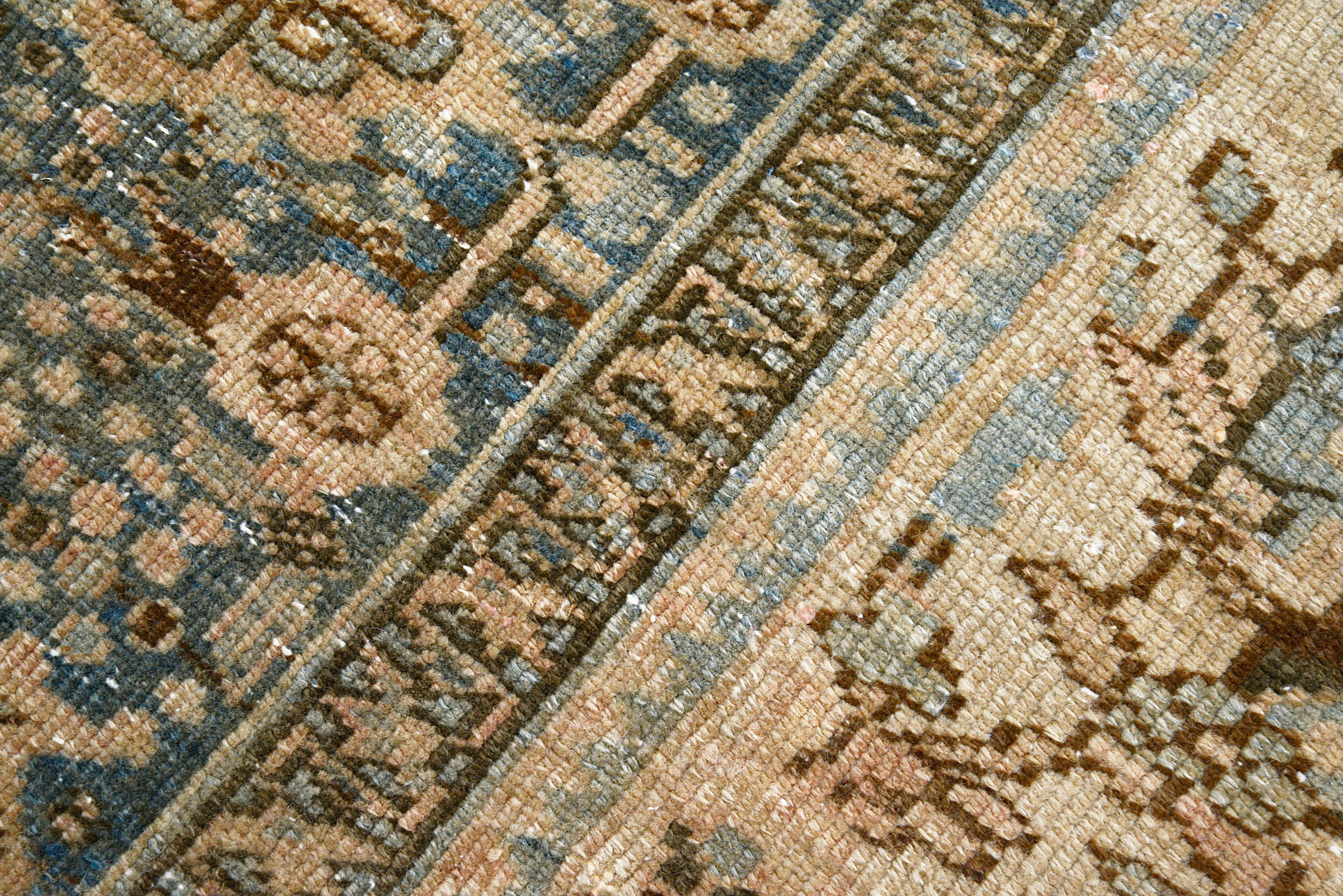 Close-up details of vintage Persian Heriz carpet showing wool texture, motifs, and natural patina
