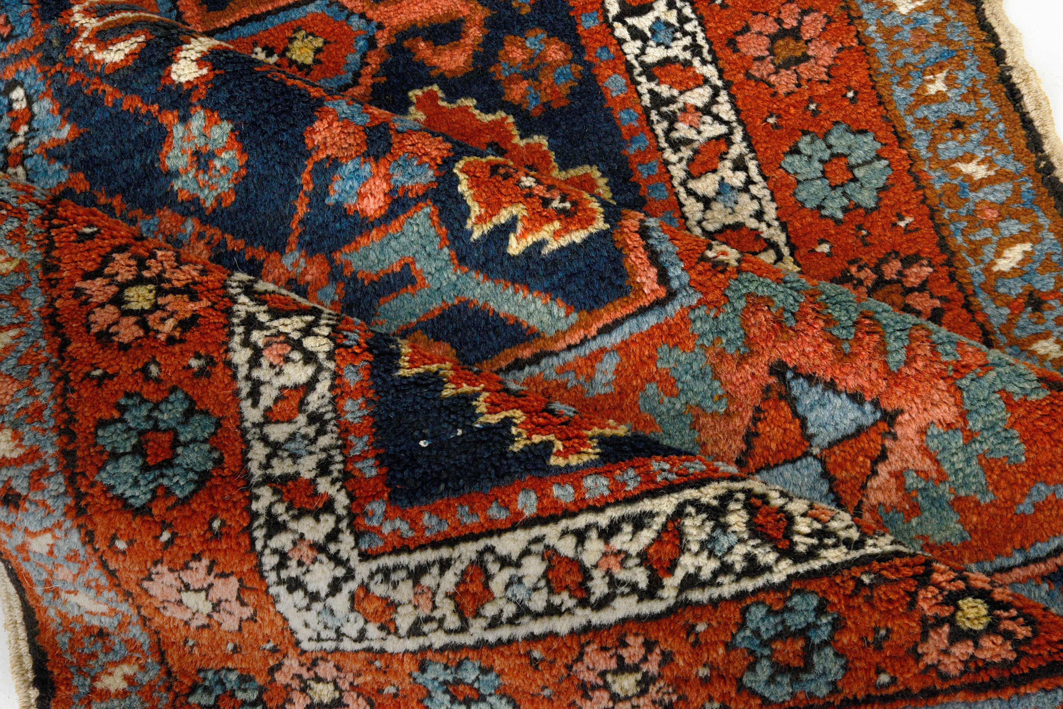 Close-up details of antique Persian Heriz rug showing wool texture, motifs, and natural ageing
