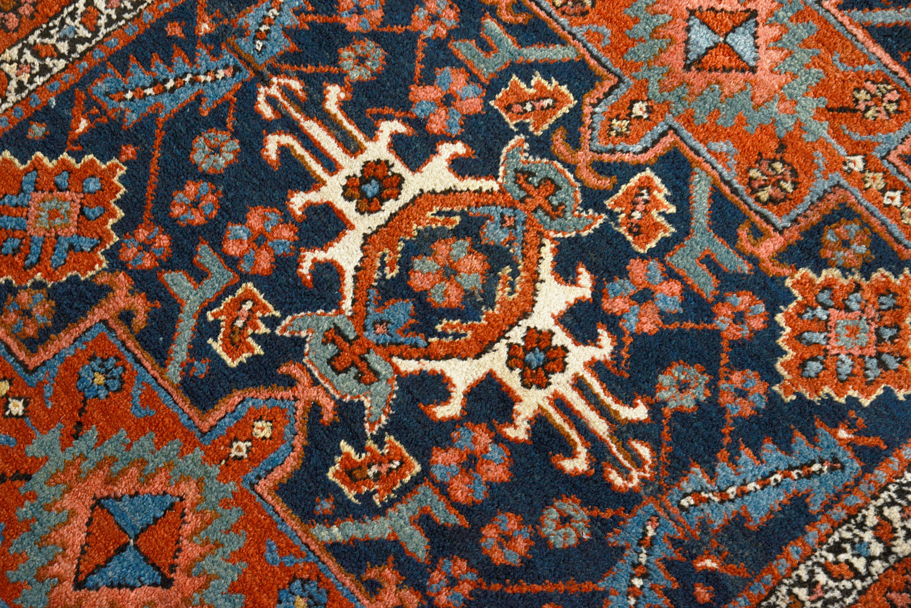 Close-up details of antique Persian Heriz rug showing wool texture, motifs, and natural ageing
