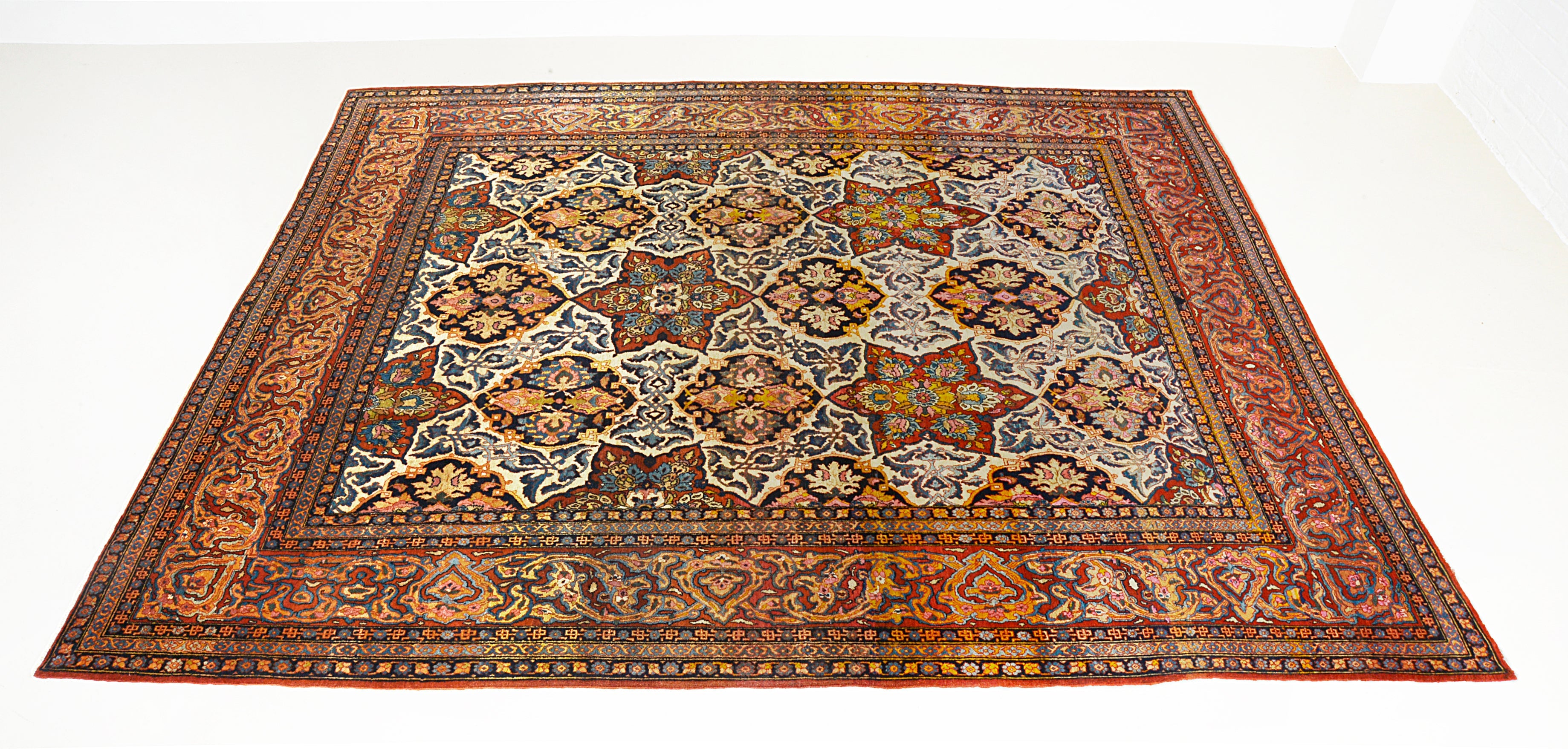 Hand-knotted antique Isfahan carpet with detailed floral design and rich natural colours

